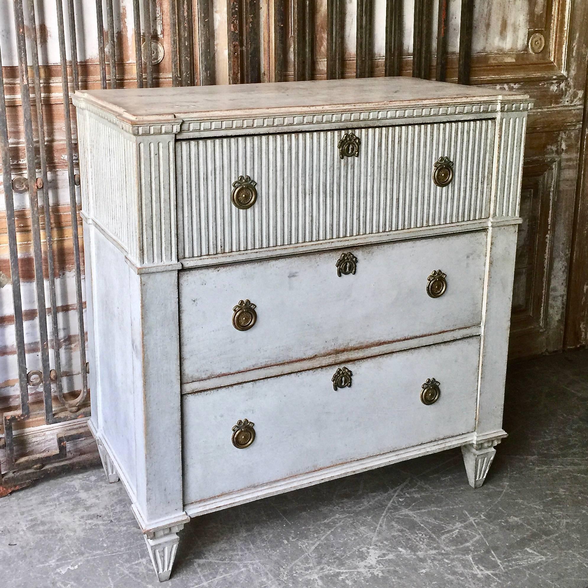 Late Gustavian period chest of drawers with fluting on front of the upper drawer and on around the side panels. Shaped top with dental trim under, reeded canted corners and classical feet. Very classical Swedish piece with original charming