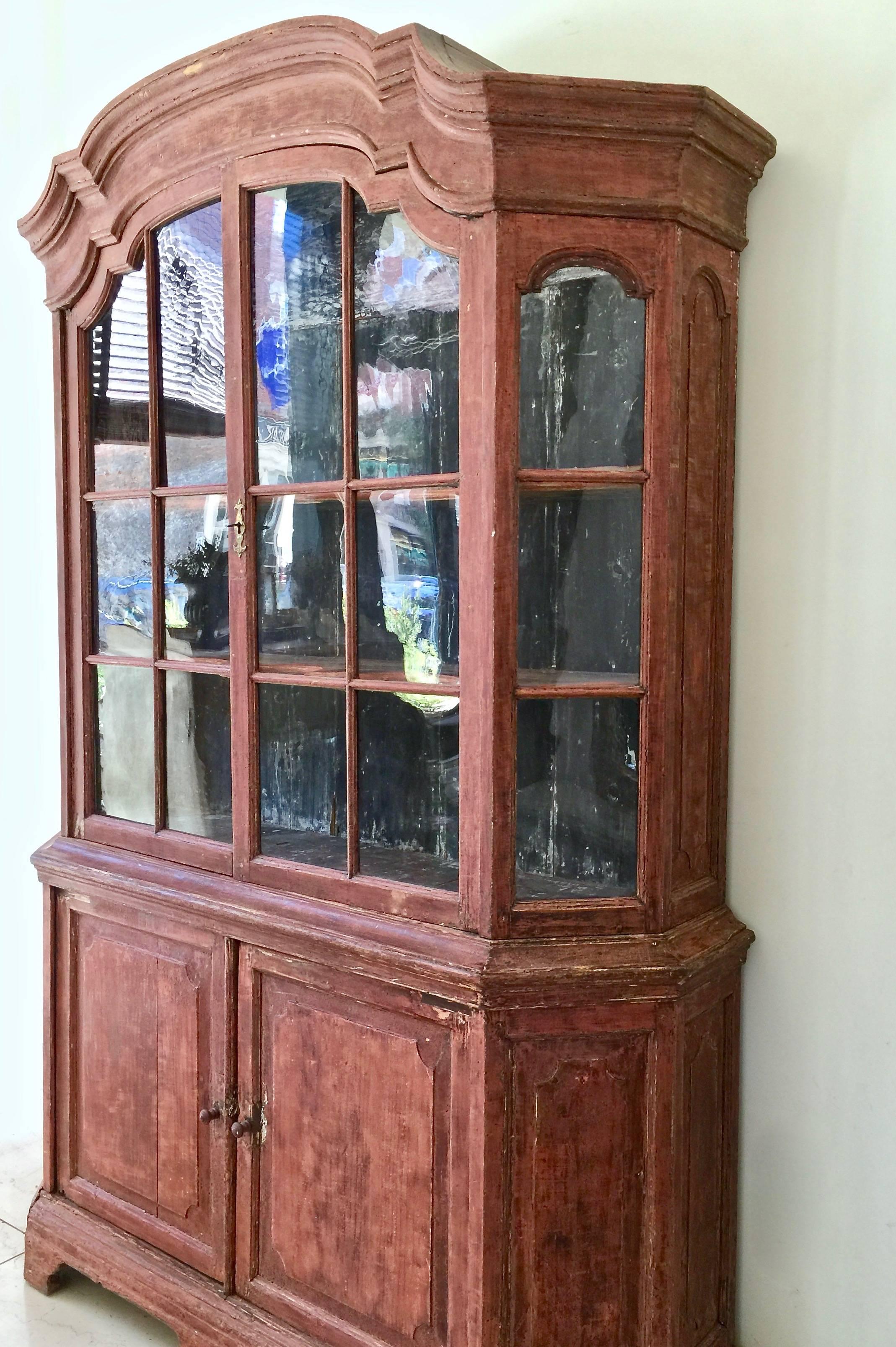 A very handsome 18th century Dutch cabinet vitrine in impressive scale with original handblown glass, scaped to most original patinated color, beautifully shaped/scalloped interior shelves, arched pediment cornice and panelled doors.