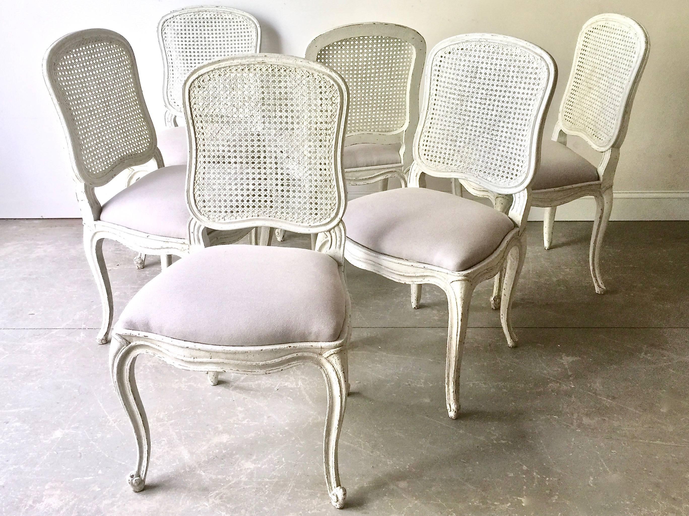 Set of six French, 19th century dining chairs Louis XV style with flat back called “la Reine” is caned and scalloped frieze carved and raised on cabriole legs. Newly upholstered in light gray linen. Seats are removable for easy re-uphostery. Very