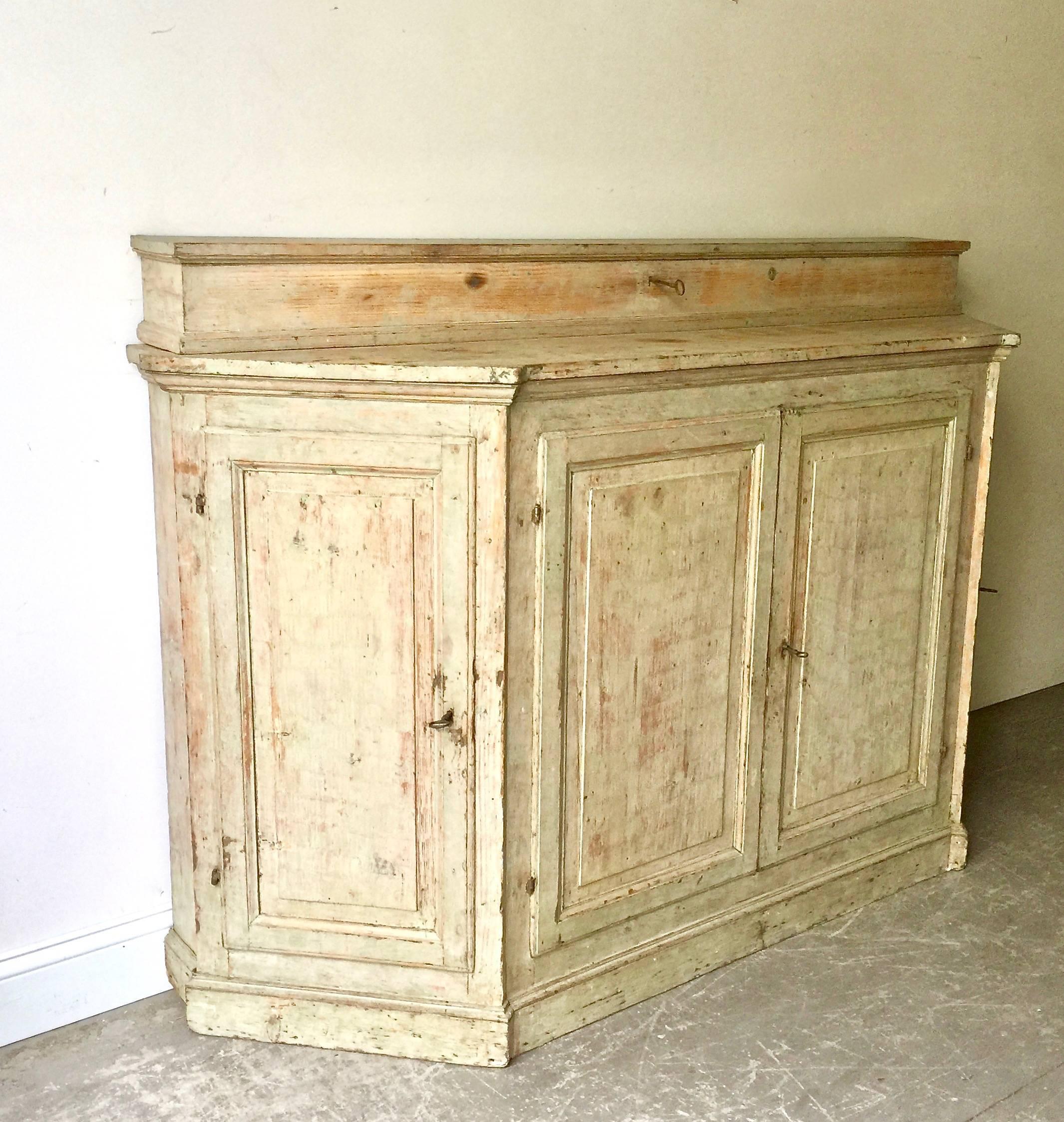 A rare four-door 18th century Italian Credenza with angled panelled doors at each corner and panelled central doors under the shaped top with unusual long lockable storage box. All in superb patinated greenish/blue original color.
Insides has been