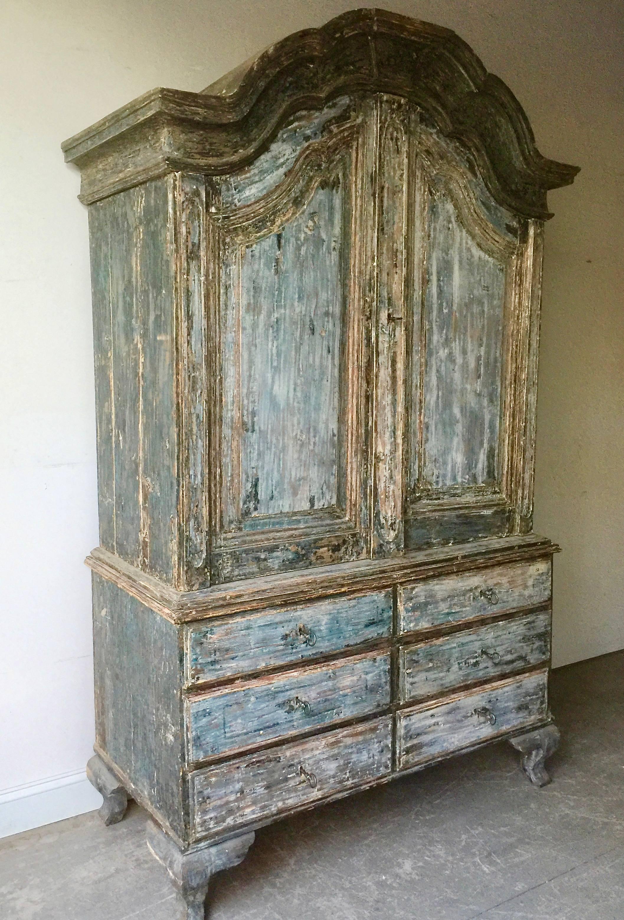 Original deep blue patinated 18th century Swedish Rococo period cabinet from Manor House, Stockholm, with wonderful arched cornice, original hardware, features two shelves and a notched spoon shelf in worn salmon color patina supported with
