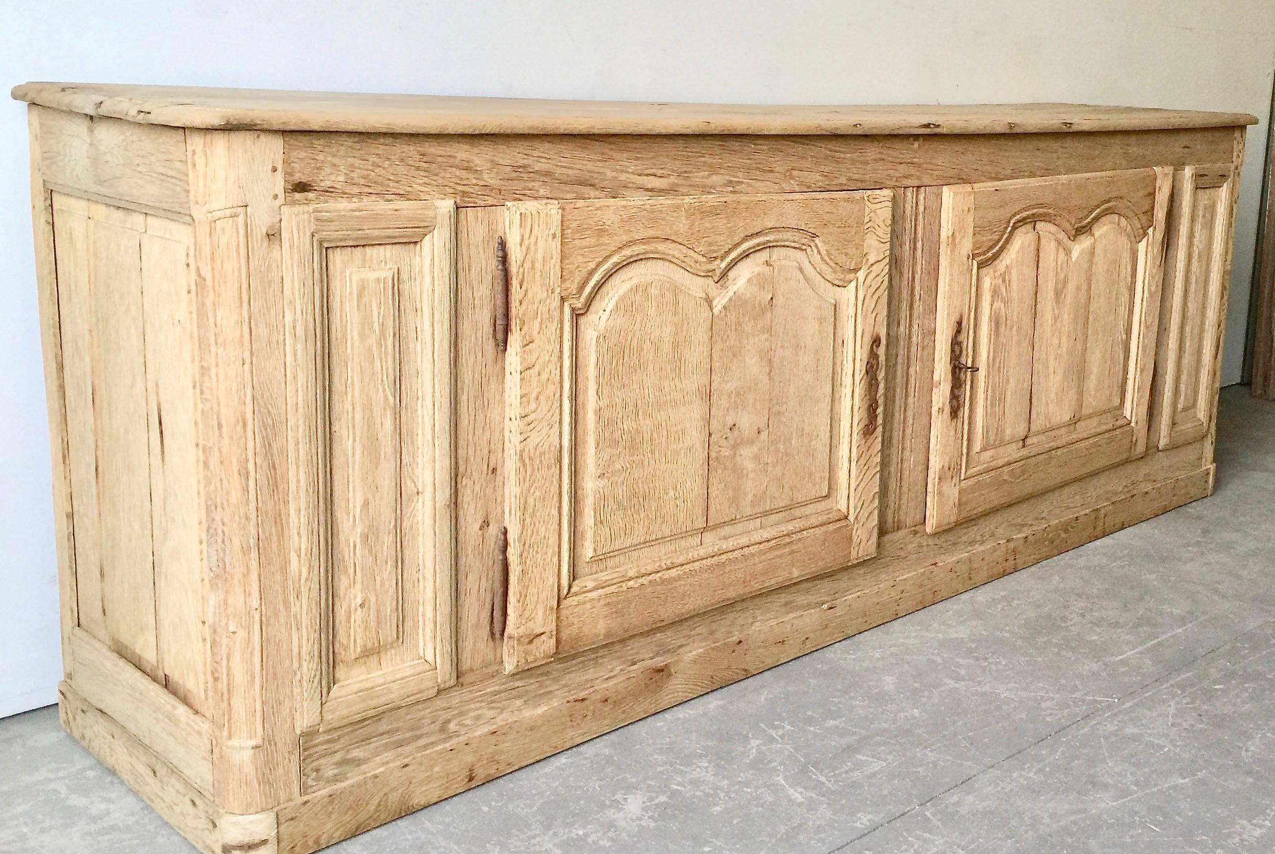 Handsome, long 19th century French sideboard, in Louis XV manner with shaped top and two richly carved fielded door panels in superb patinated natural oak. Original rustic ironwork. 
France, 19th century. 
More than ever, we selected the best, the