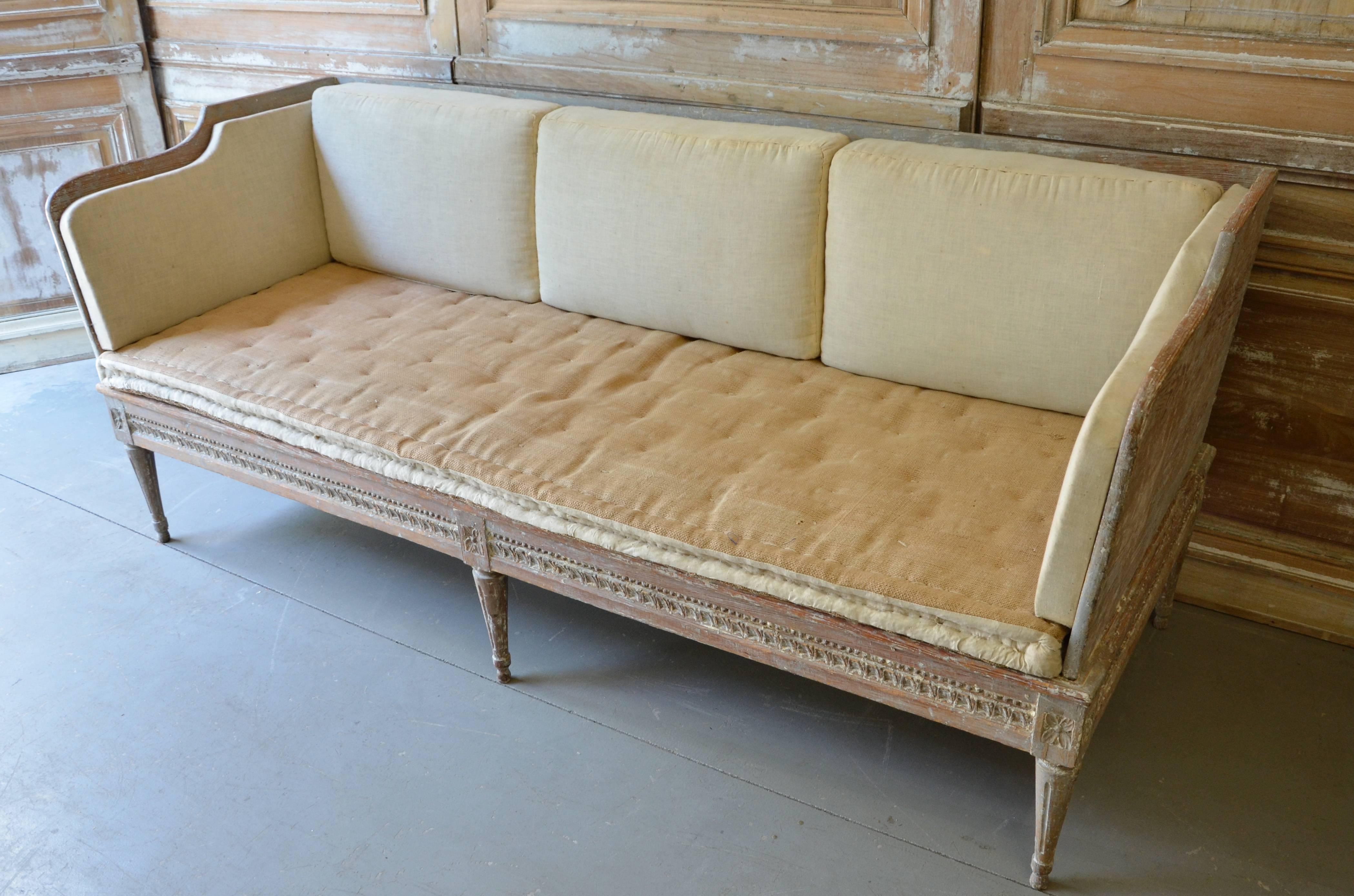 18th century Swedish Gustavian period "Trågsoffa," finished on three sides with leaf rod and floral rosette medallions above reeded legs. Scraped to original cream white/blue finish. Original cussions ready for new upholstery.
Stockholm,