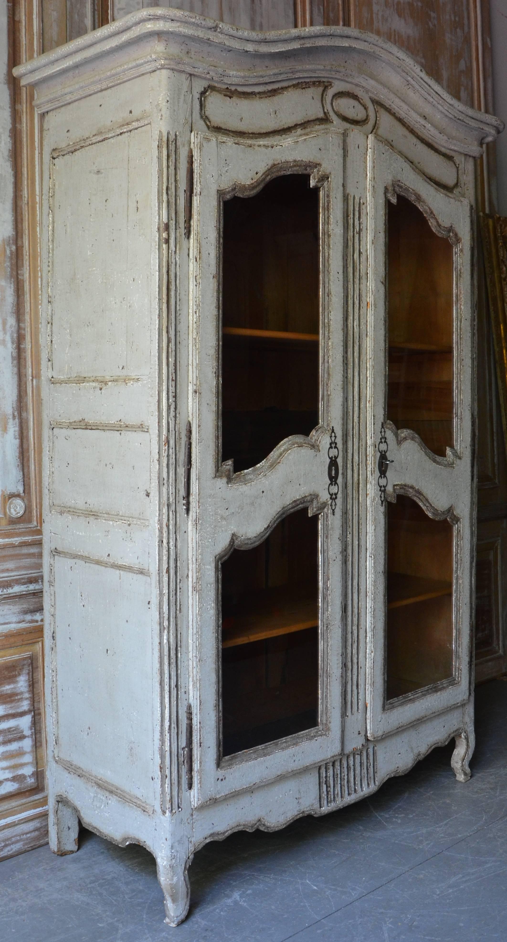 French Louis XV-style Bibliothèque in painted walnut wood with a Chapeau de Gendarme crown, double glass doors, original hardwares and three inside shelves.

Measurement without cornice:
W: 50.75