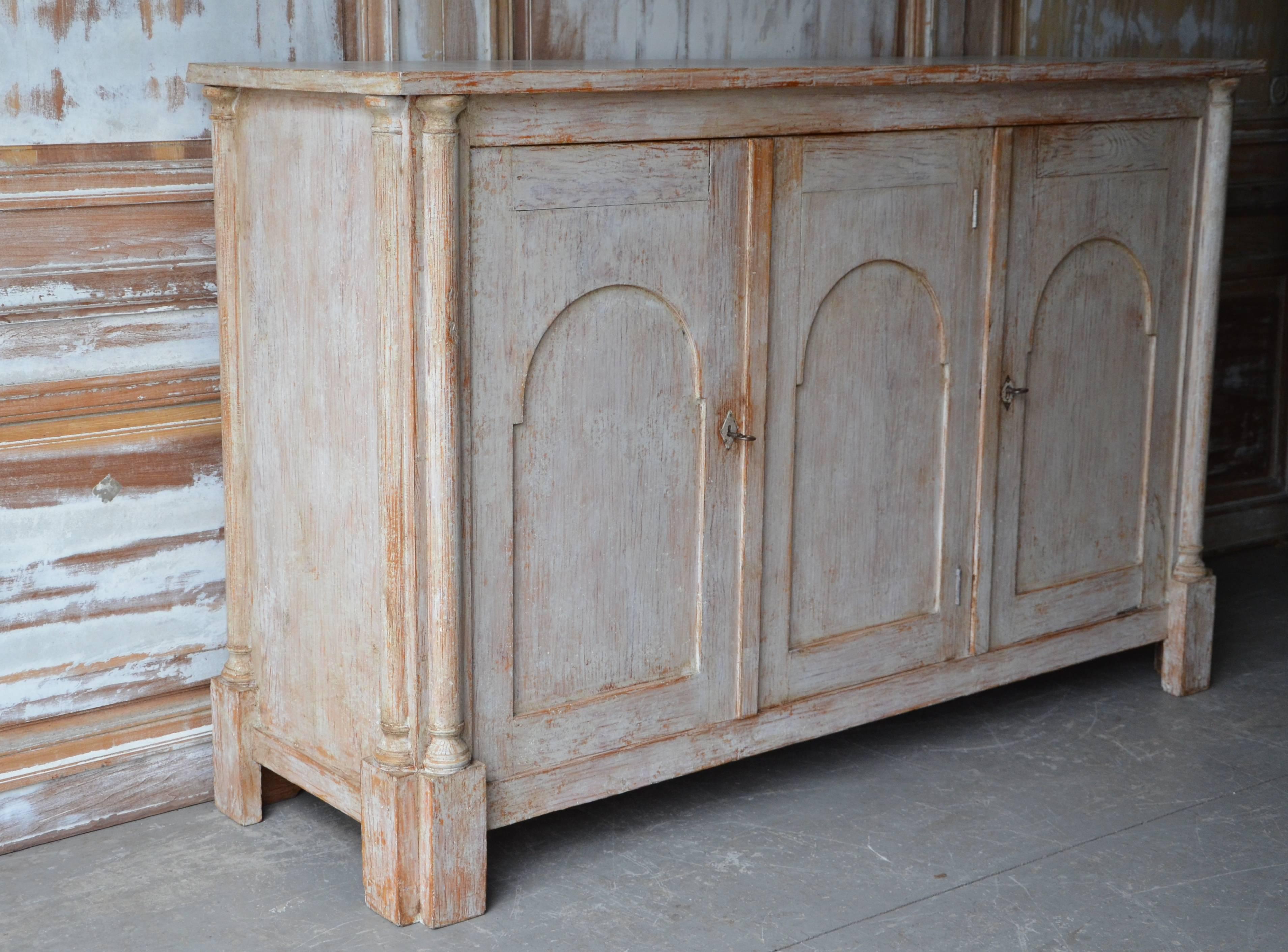 Large, very handsome early 19th century Swedish Gustavian sideboard with three carved arched doors and neo classical columns to each corner in worn light gray patina.
Hälsingland, Sweden, circa 1830.
    
  