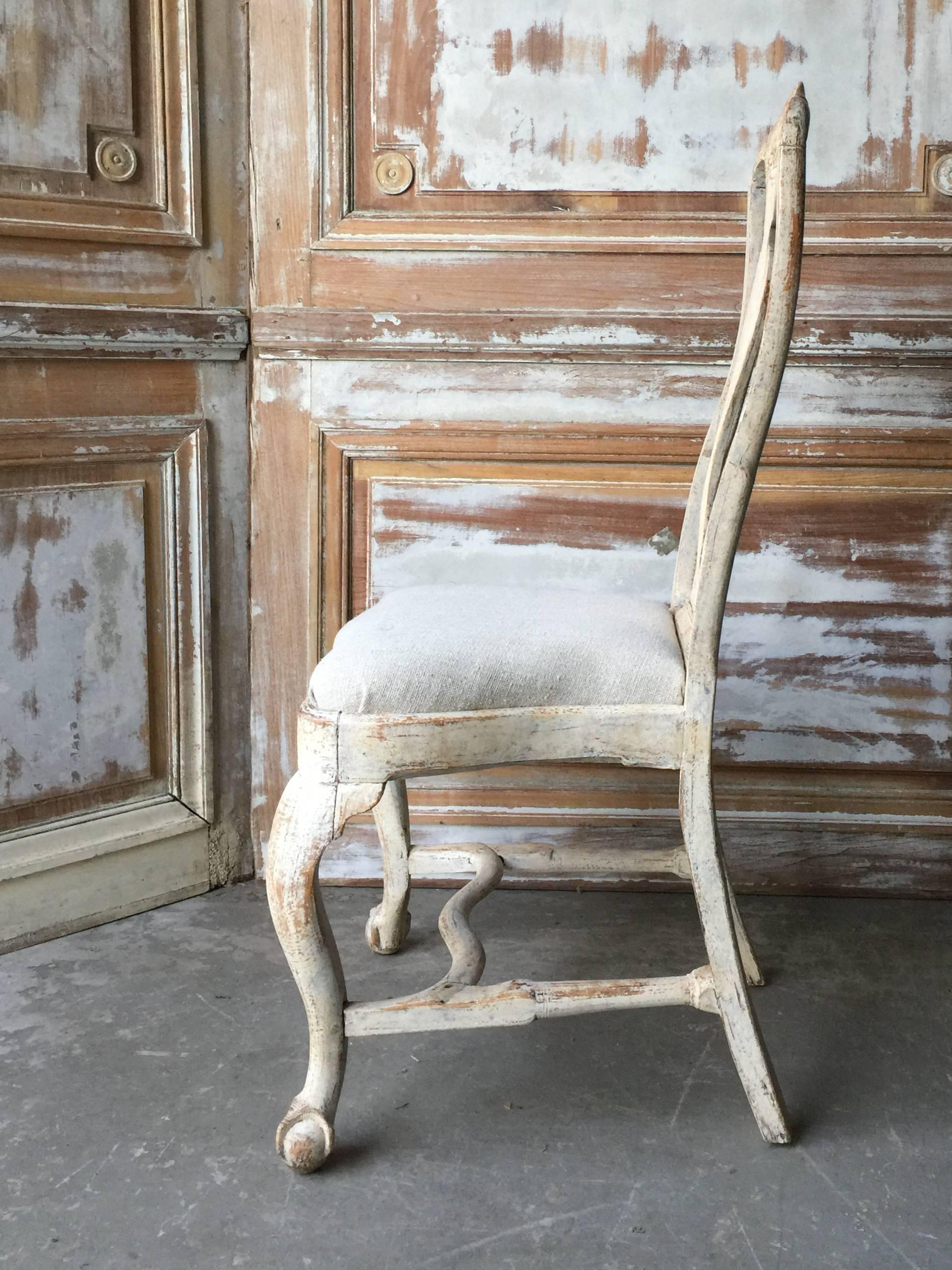 18th century Swedish chairs, in Rococo period circa 1760 with lovingly handmade rocaille carving on the seat rails and pierced splats. Hand scraped back to traces of their original worn cream paint, circa 1760, Göteborg, Sweden. Measures: Seat 14
