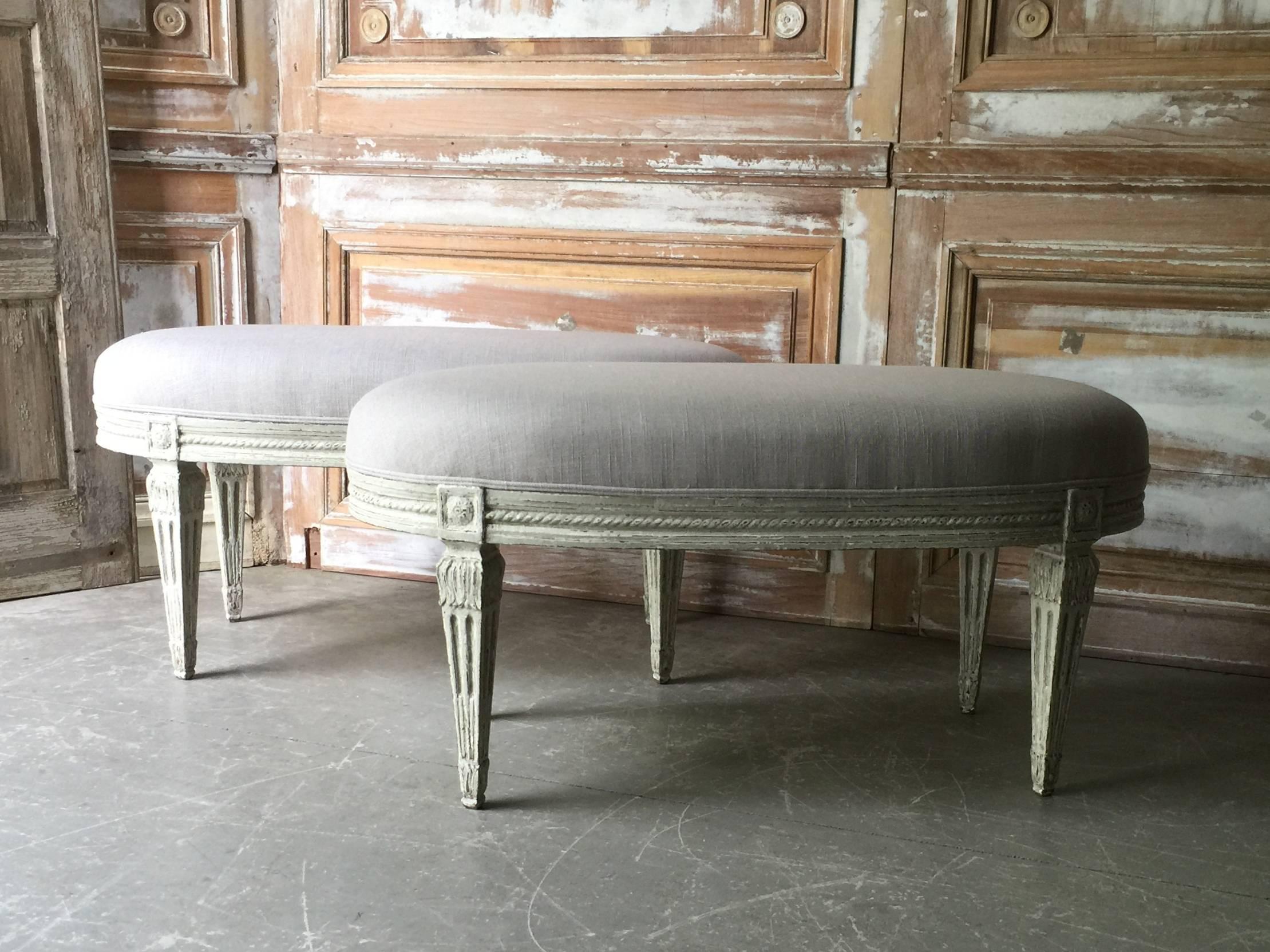 Pair of Louis XVI style French benches in oval shape with richly carved frieze and fluted tapered legs. Upholstered in linen.
Condition: Excellent.