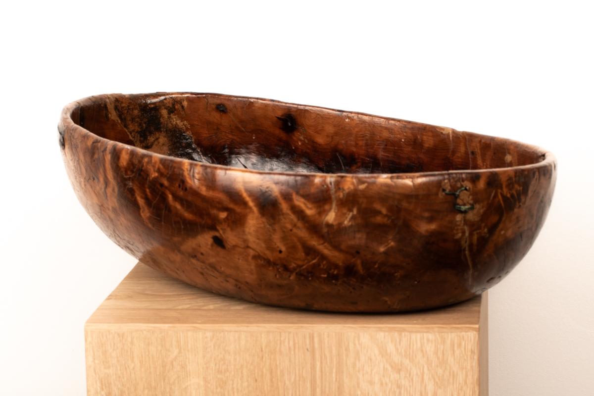 A richly patinated 19th-century Swedish allmoge bowl, hand-carved from a solid burl, exhibiting a mesmerizing interplay of wild woodgrain, deep texture, and organic irregularity. This exceptional folk vessel bears signs of honest use and