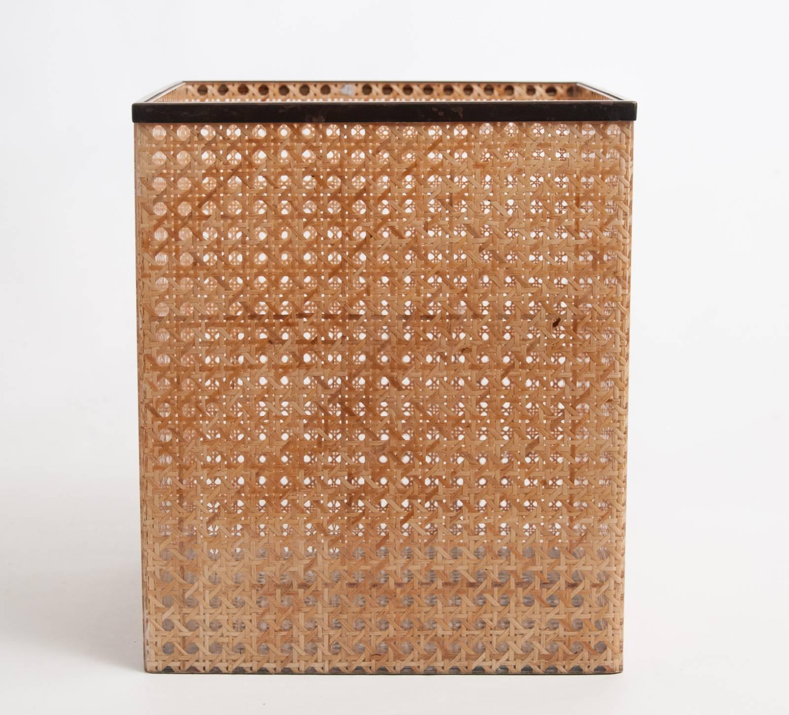 Large and stylish Mid-Century wastepaper basket made from Lucite with embedded cane work with brass edging attributed to Christian Dior Home collection.