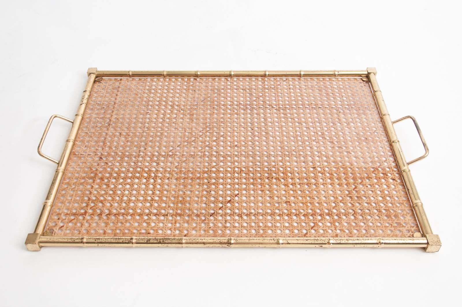 Large and stylish Mid-Century serving tray comprised of a large sheet of Lucite with embedded rattan/cane work in a faux bamboo brass frame possibly supplied by Christian Dior Home, Italy, circa 1970.