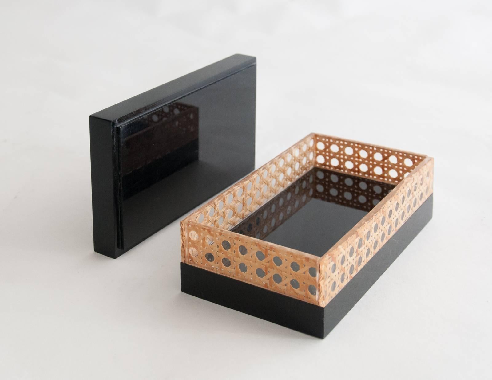 Midcentury black Lucite and embedded cane work decorative box attributed to Christian Dior Home Collection in 1970s. Rectangular shape with rattan canework embedded in clear Lucite.
Probably made in Italy for the French market.