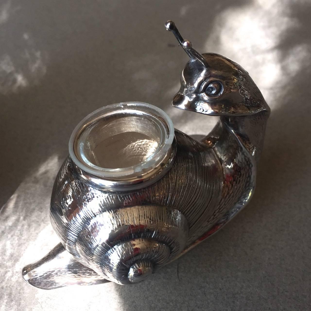 Camusso set of four sterling silver snail salt cellars, Peru.

A set of four, intricately detailed snail salt cellars. Each snail has a large shell with spiral stripes. The snail's body, including the head and foot, extends below the shell with