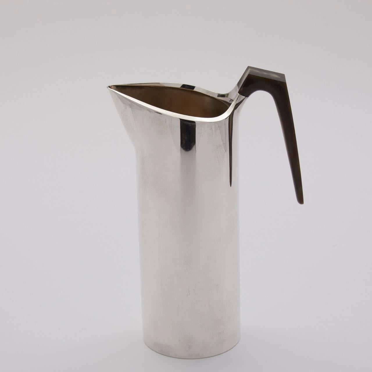 Hans Hansen sterling silver drinks pitcher

Wonderful and bold pitcher made as a limited edition in 1989. Straight cylindrical body with angle cut polished horn handle. Very sleek.

About the designer:
Hans Hansen (1884-1940) opened his own