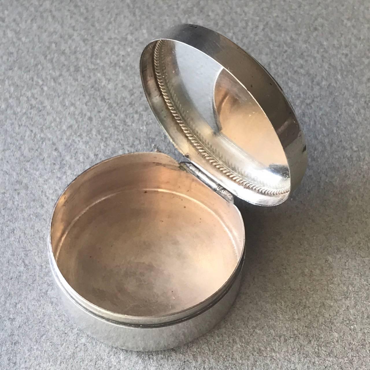 Georg Jensen sterling silver compact

A Classic Art Nouveau style petit compact made by Jensen in the 1930s. The round body having raised decoration and hinged lid inset with malachite cabochons to the top and a mirror to the interior. Charming.