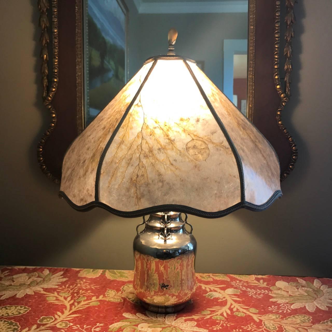 Mogens Ballin 826 silver lamp with custom shade.
This piece was a custom silver vase that was later converted to a lamp without damaging the vase. This rare piece is entirely handmade with beautiful details and hand hammering and chased leaves.