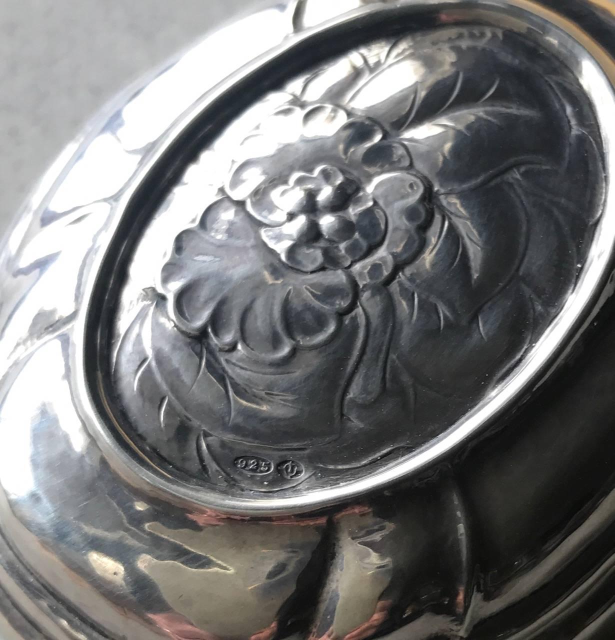 Georg Jensen sterling silver small keepsake box, no. 142A.

Rare find. Scalloped shape oval. Floral chased top, hinged lid.

Bearing English import marks from 1924 and discreetly engraved with the initials, F.A.M., circa 1924-1932

Excellent