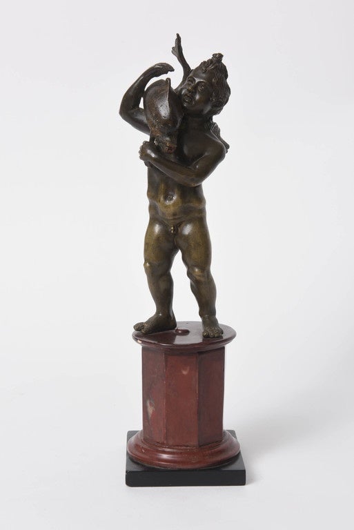 This handsomely modeled bronze sculpture of Cupid (Eros) carrying a dolphin on his shoulder is based on a sculpture discovered at Pompeii in the 18th century.  

Mounted on a modern octagonal marble base.

Overall height is 13.5 inches.  The