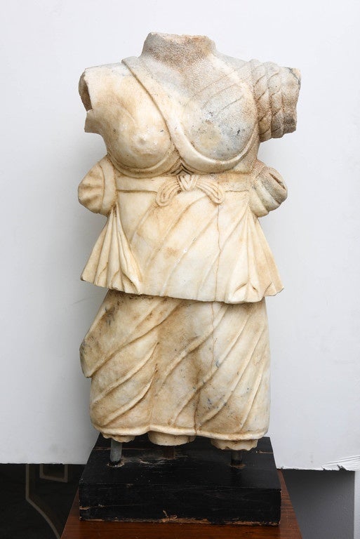 This impressive marble torso of the virgin huntress Diana, goddess of the hunt, the moon goddess, and guardian of wild animals, and daughter of Zeus and Leto. She is wearing a short dress (chiton). It is based on a Roman 1st century model. Age