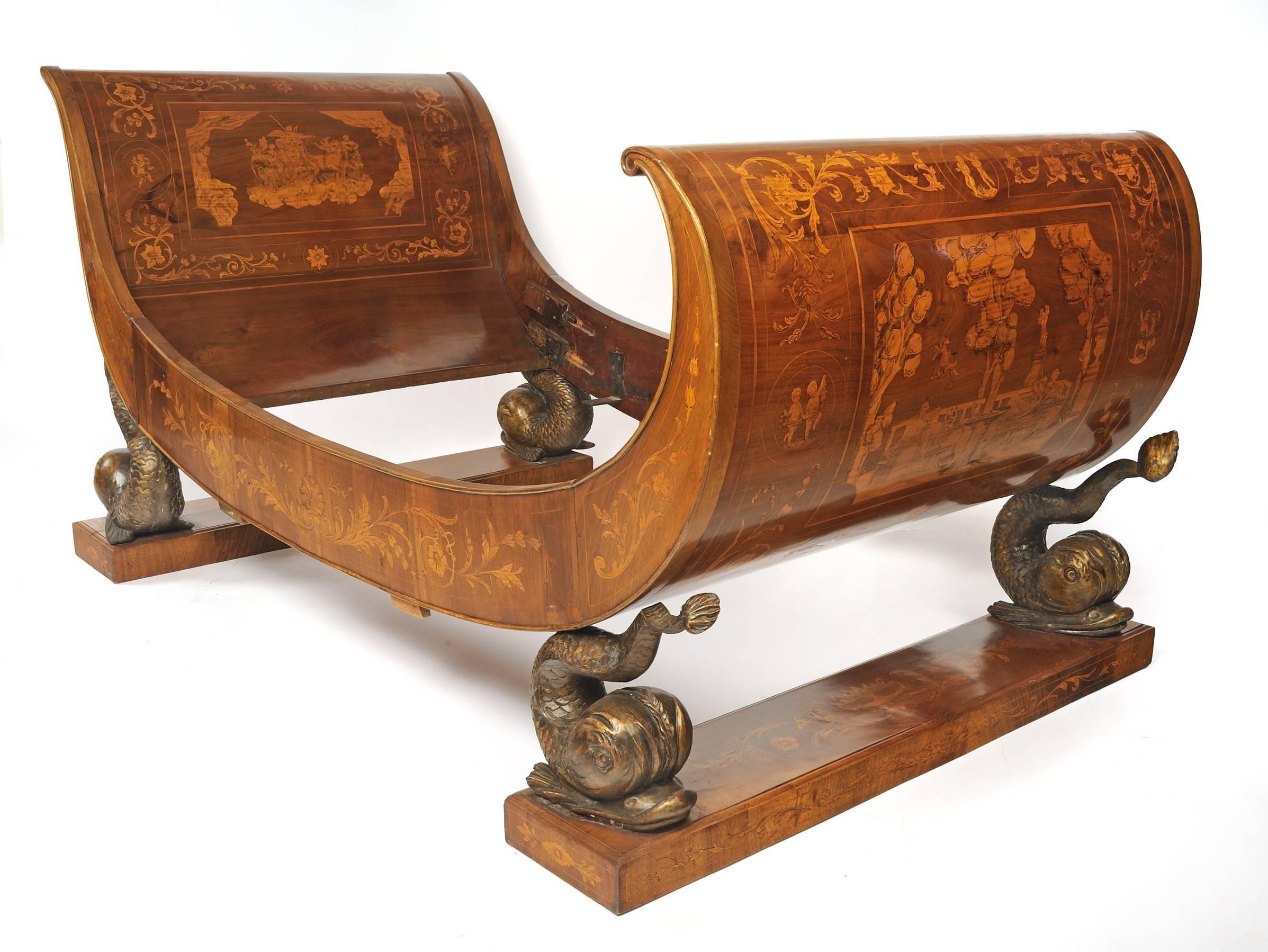 Early 19th century continental marquetry and mahogany sleigh bed.
Lucca, Tuscany.

An exquisite example of Italian marquetry work, this early 19th century mahogany sleigh bed rests upon four ornate and fantastical depictions of swimming dolphins,