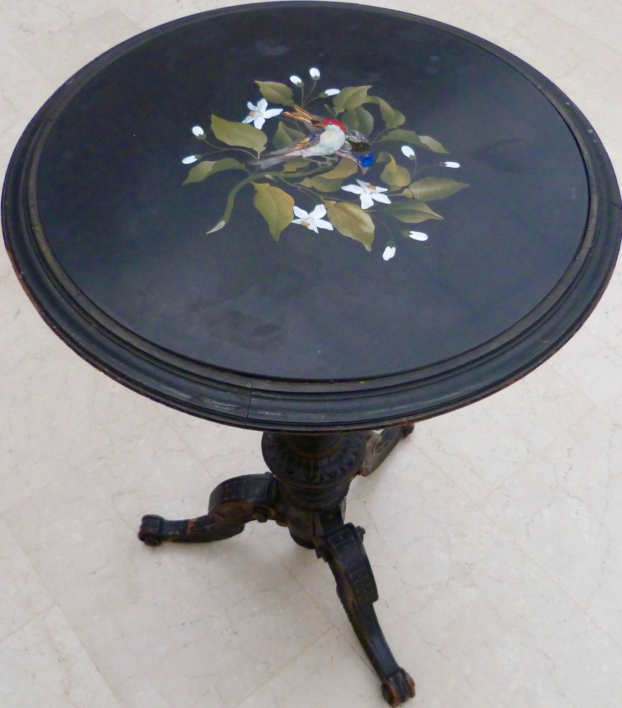A 19th century Italian Pietra Dura round table.
Possibly Tuscany (Florence) Italy Pietra Dura inlaid slate inserted in a wooden ebonized carved base.