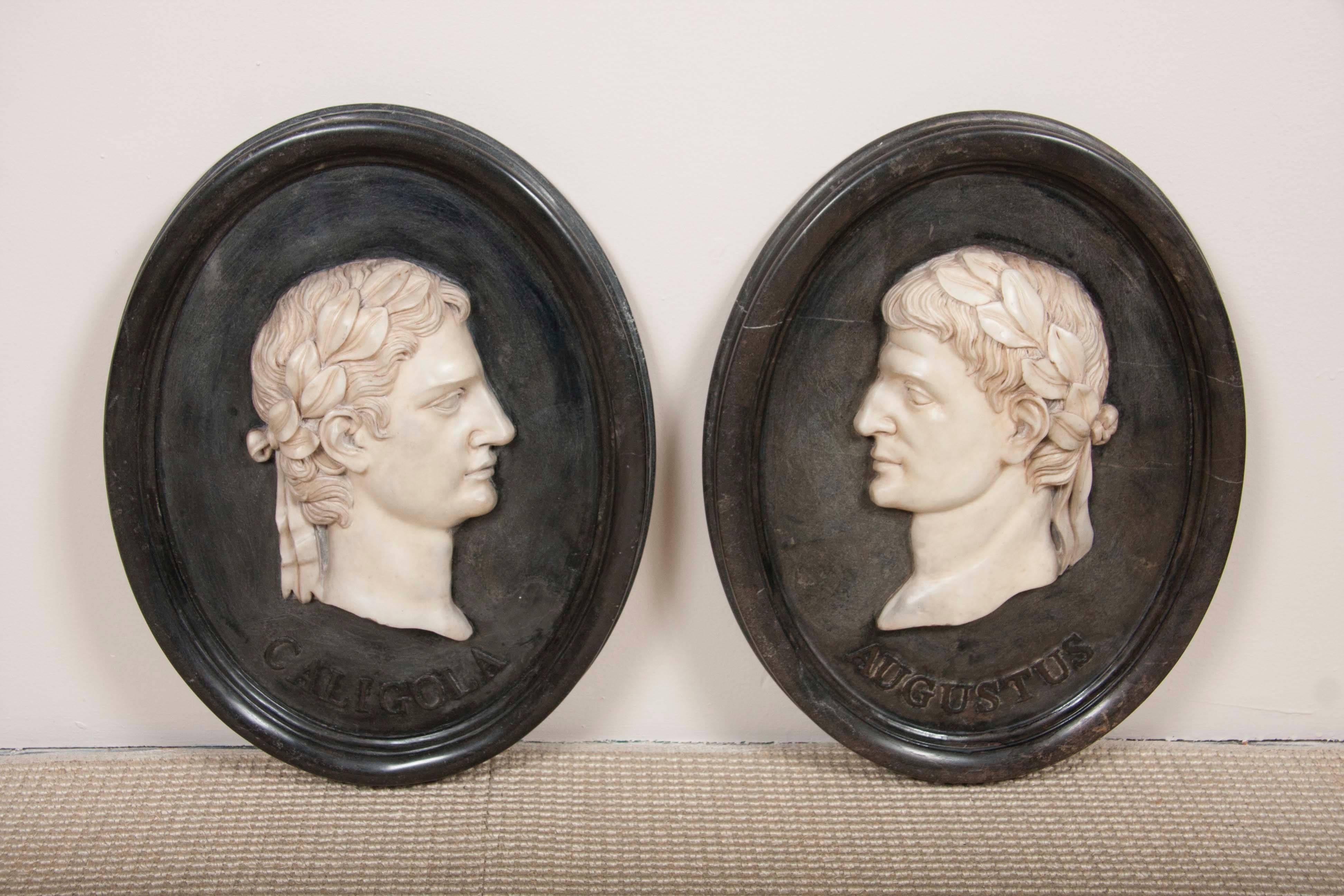 A pair of 19th century Italian Grand Tour marble faced plaques, mounted on oval marble frames, representing two Roman Emperors, Caligola and Augustus.