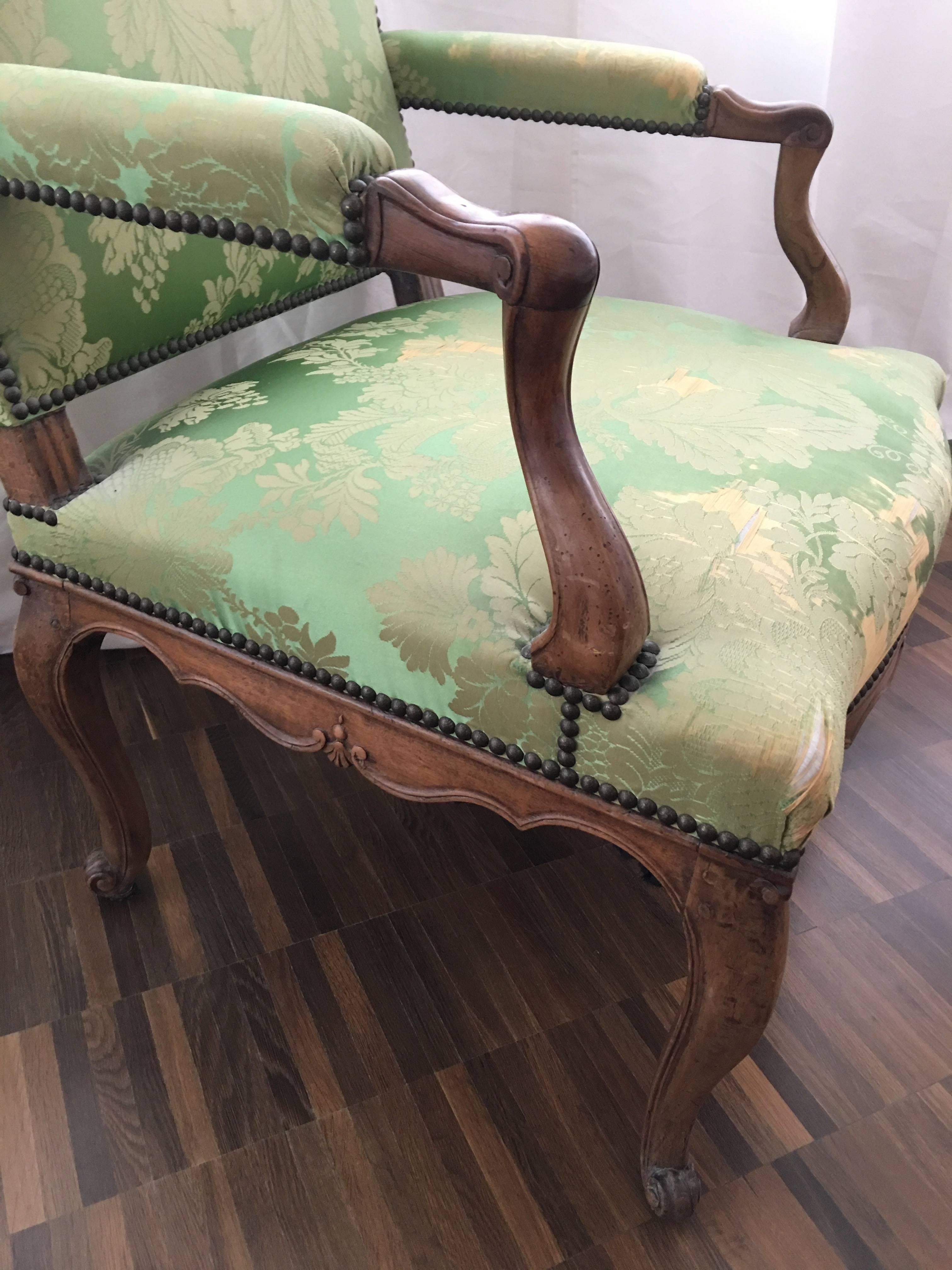 A single 19th century French Louis XV Regence Fauteuil a la Reine/armchair.

Made of a walnut frame, decorative nails head and escargots feet. 

A comfortable tall back armchair.
