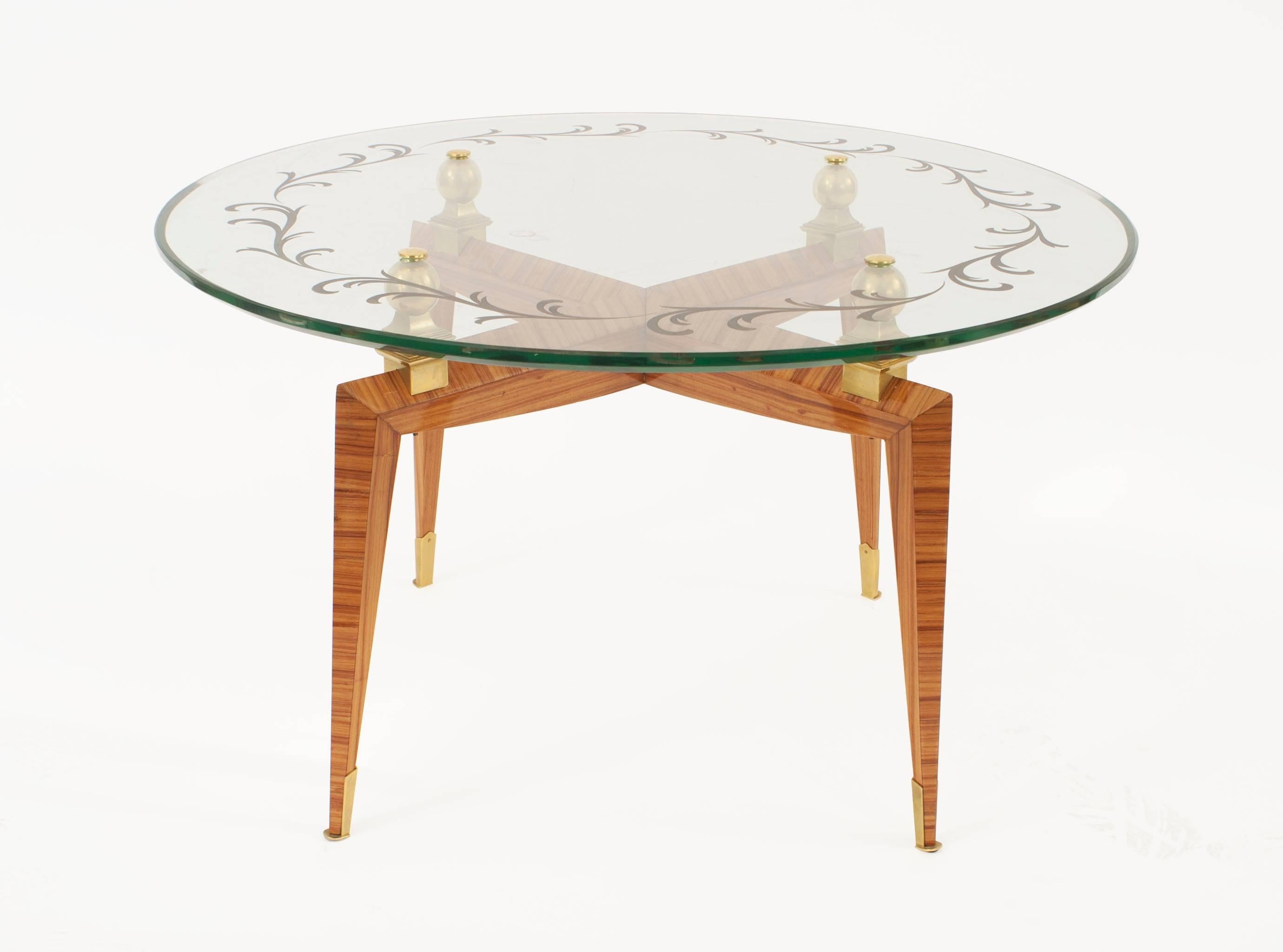 French midcentury tulip wood coffee table with four legs connected by a stretcher having gilt bronze sabot feet with four gilt bronze balls supporting a gold floral engraved round glass top (Etienne-Henri Martin).


Etienne-Henri Martin was a French