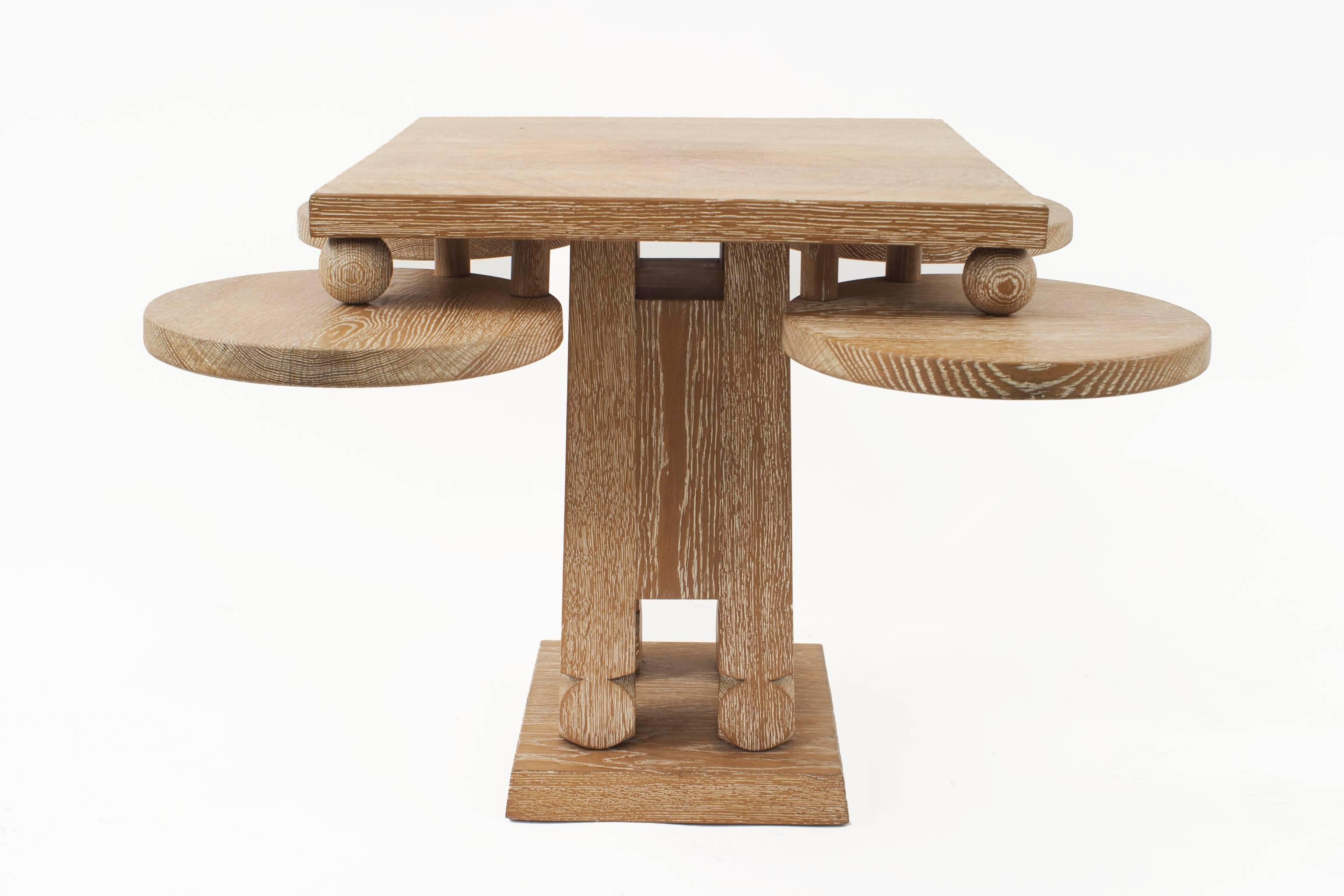 French midcentury (1940s) bleached cerused oak game table with four circular corner panels supporting balls under a square top and square pedestal base.
 