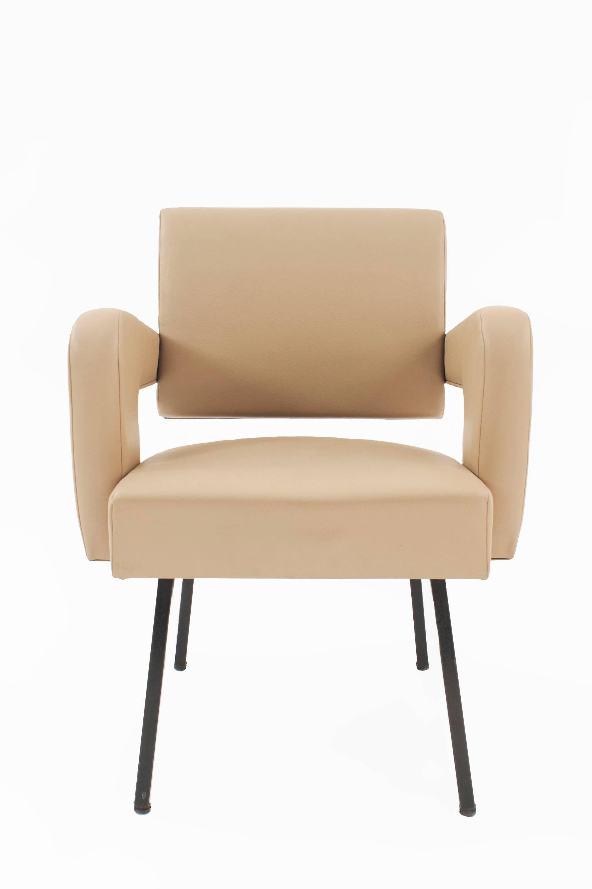 Pair of French midcentury open armchairs upholstered in a light beige leatherette supported on black metal legs (JACQUES ADNET, ref: pg 133 ADNET).

Jacques Adnet is a distinctive figure of French twentieth-century design. Spanning the Art Deco