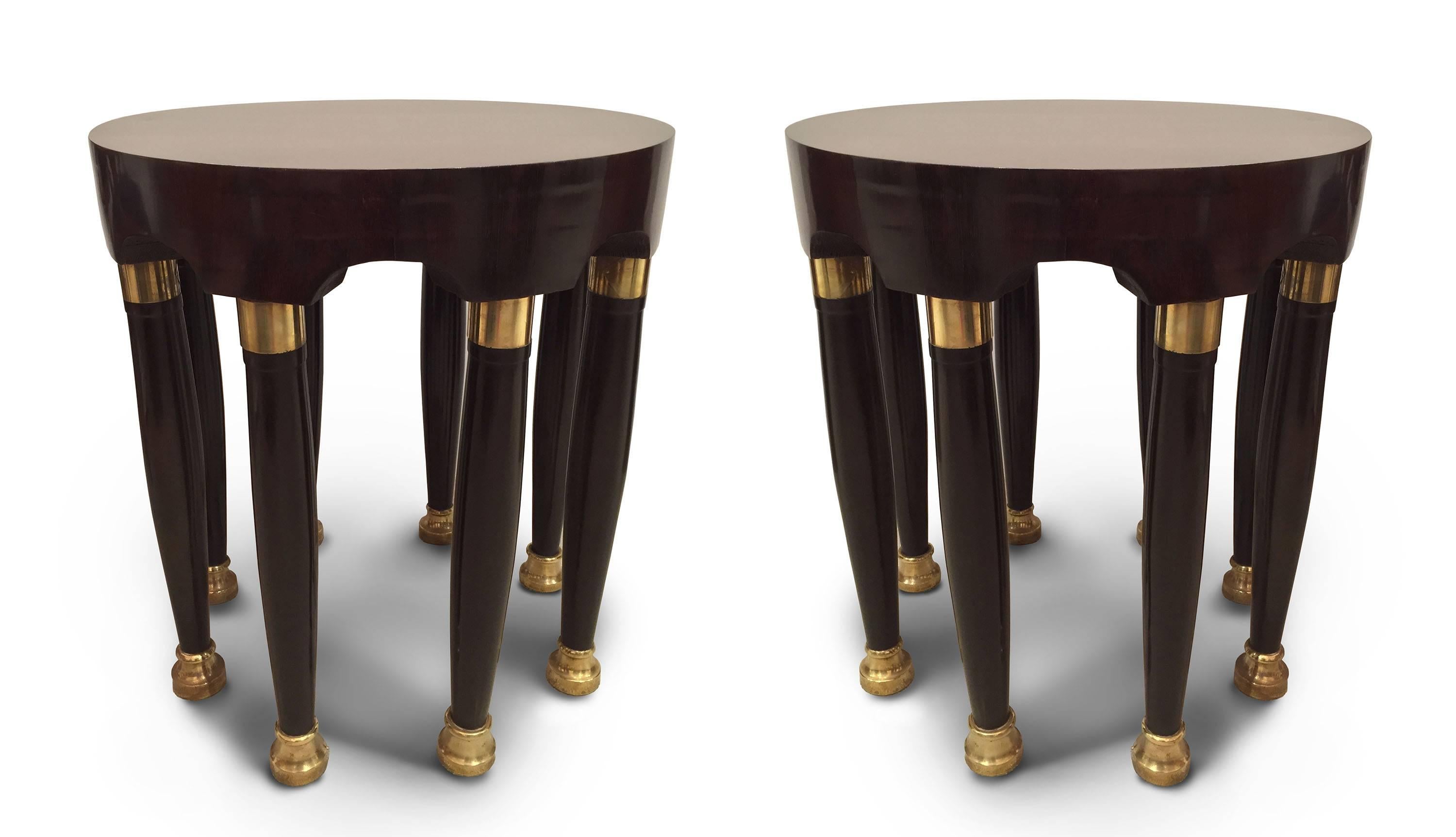 Pair of Continental (possibly Austrian) Art Deco round mahogany end tables
supported with eight ebonized legs having gilt trim brass round feet.