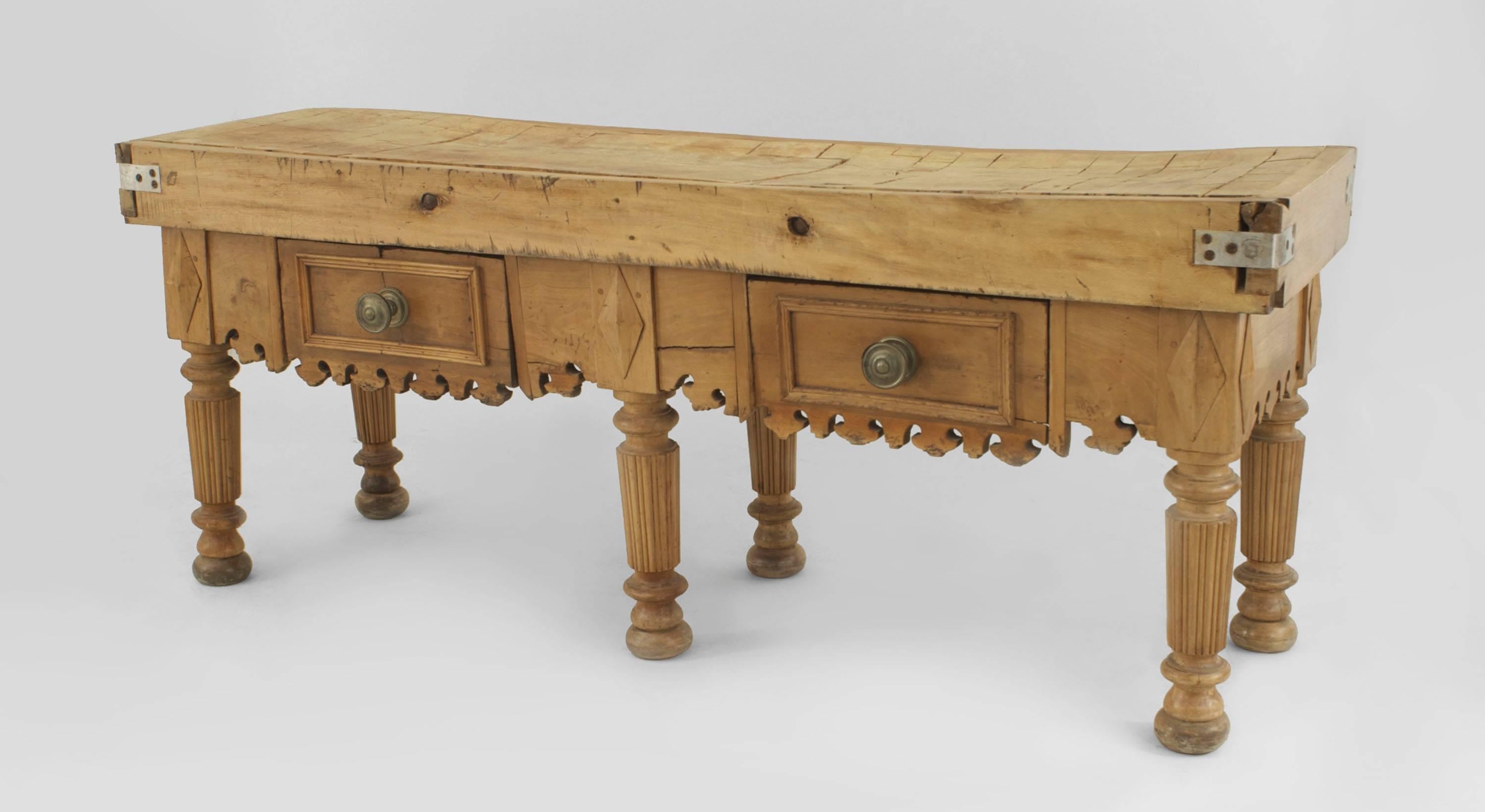 English Country style (19th century) large pine rectangular butcher block table standing on six fluted legs having two drawers with large round brass knobs and a double thick top with a carved apron (some recent modifications added).
