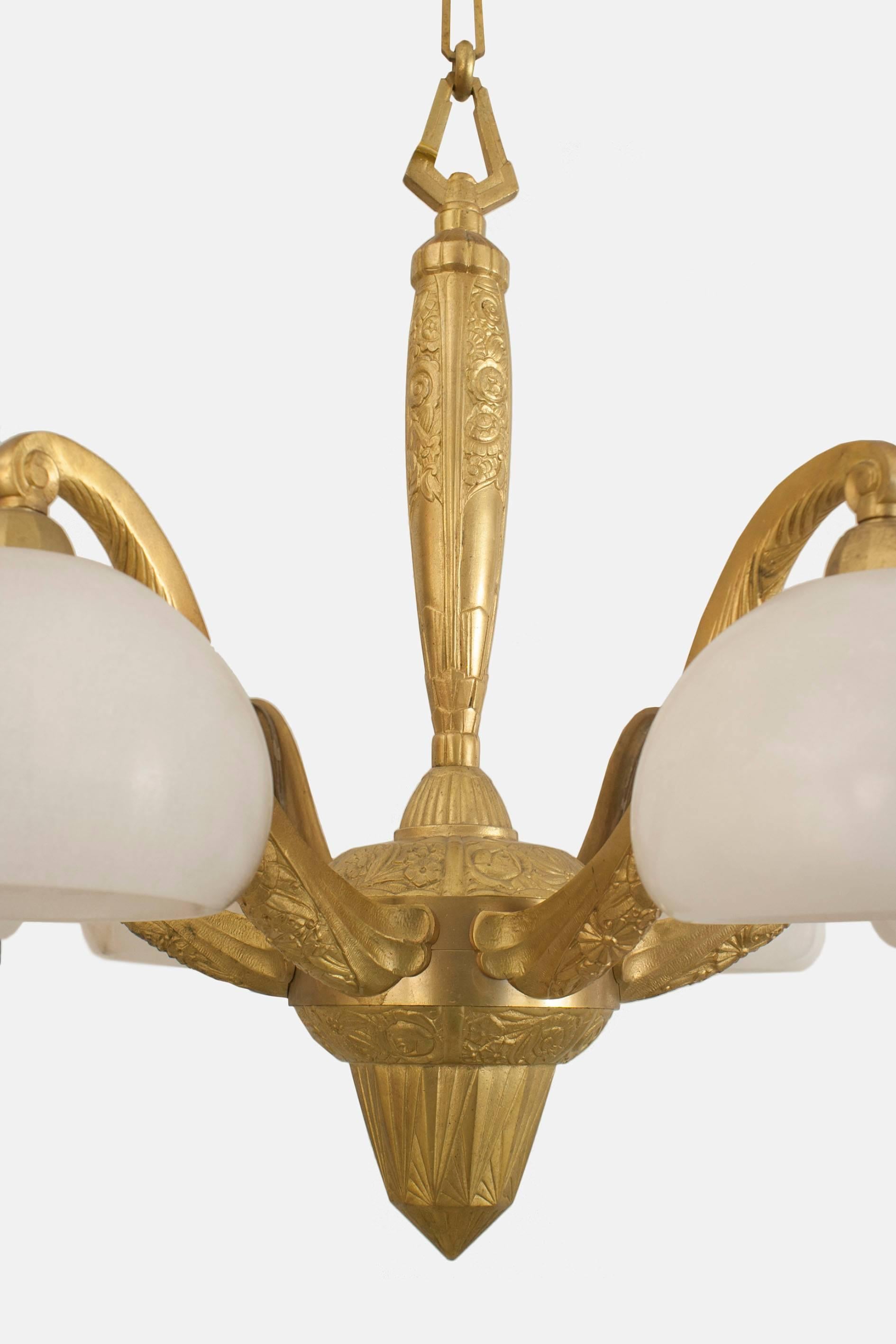 Lustre Art Déco français en bronze doré avec un design géométrique et floral ayant 6 bras à volutes supportant des abat-jour en forme de bol en albâtre. (Attribué à SUE ET MARE)
