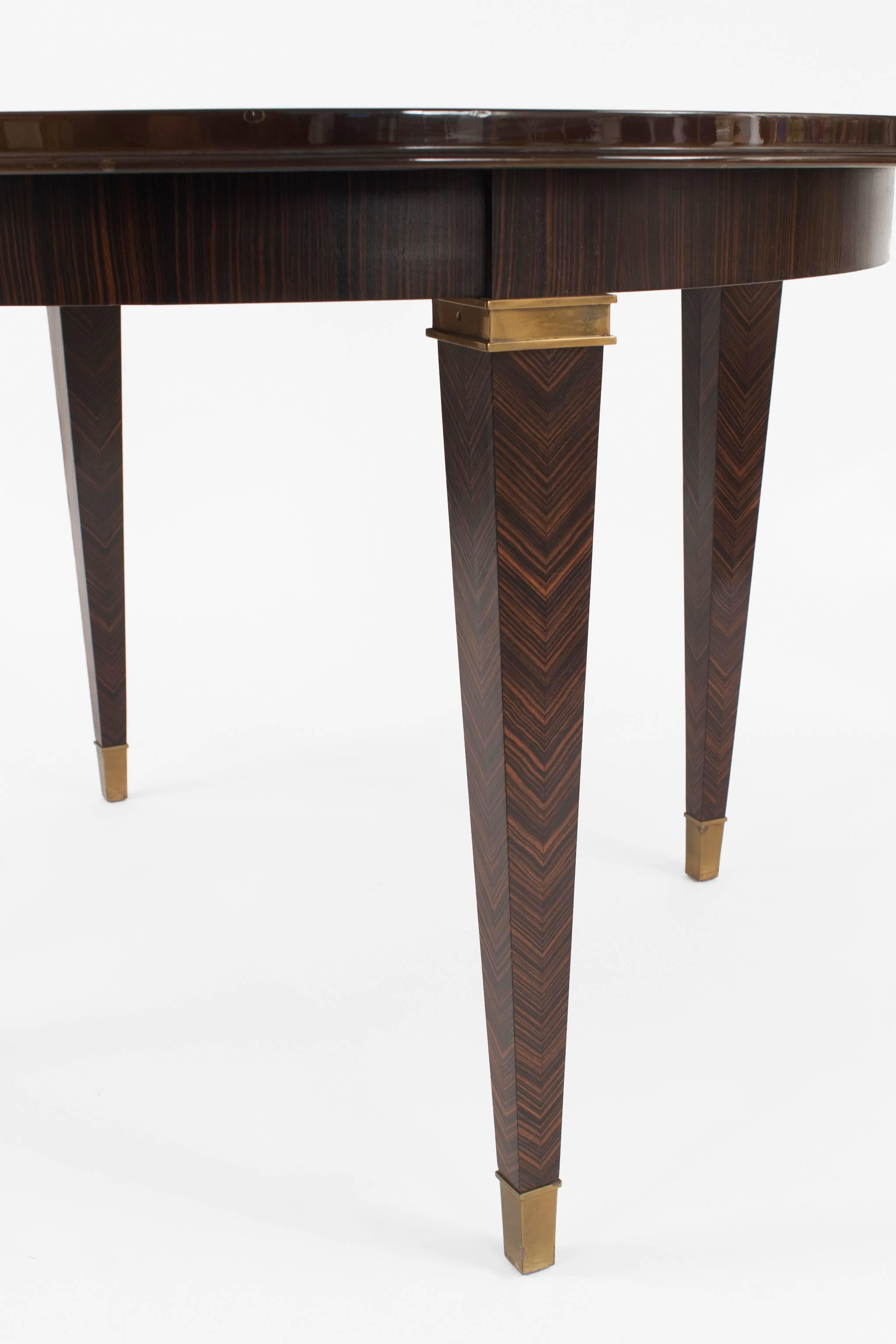 French Art Deco (1930s) round dining table with a brown lacquered top (by Atelier Sain et Tambuté, Paris) over four tapered Macassar wood legs with bronze trim by Dominique. *No leaves.


The decorating firm of Dominique was established in l922 at