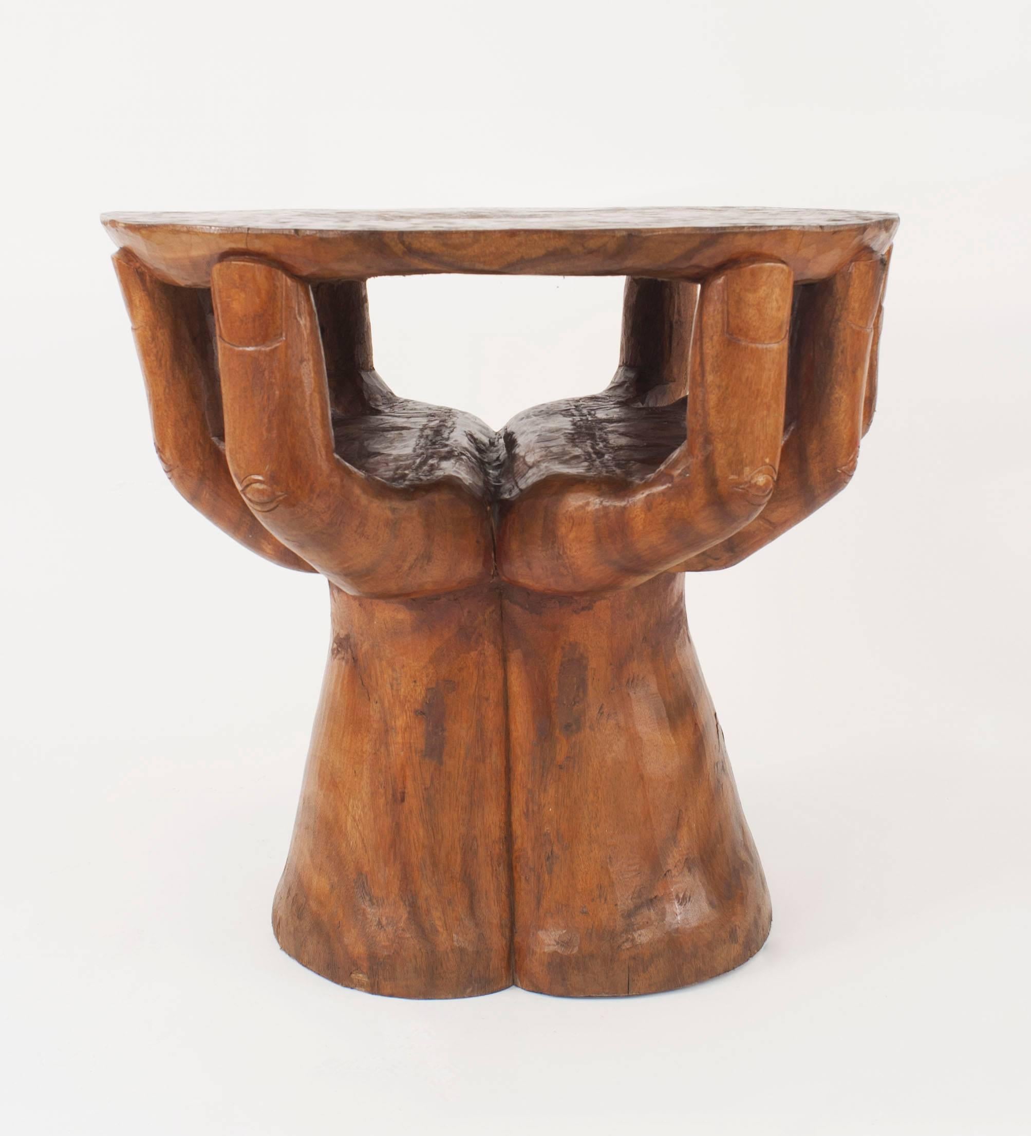 Rustic American walnut carved centre/end table with a base of two carved hands with fingers supporting a round shaped top, second quarter 20th century. (style of Pedro Friedeberg).
 