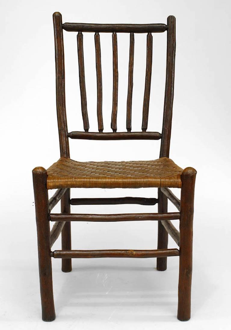 Set of four Rustic Old Hickory side chairs with 5 spindle back above a rattan seat and legs joined by a box stretcher (circa 1935, branded: Old Hickory/ Furn Co/ Martinsville Ind)(similar to #059702).
  