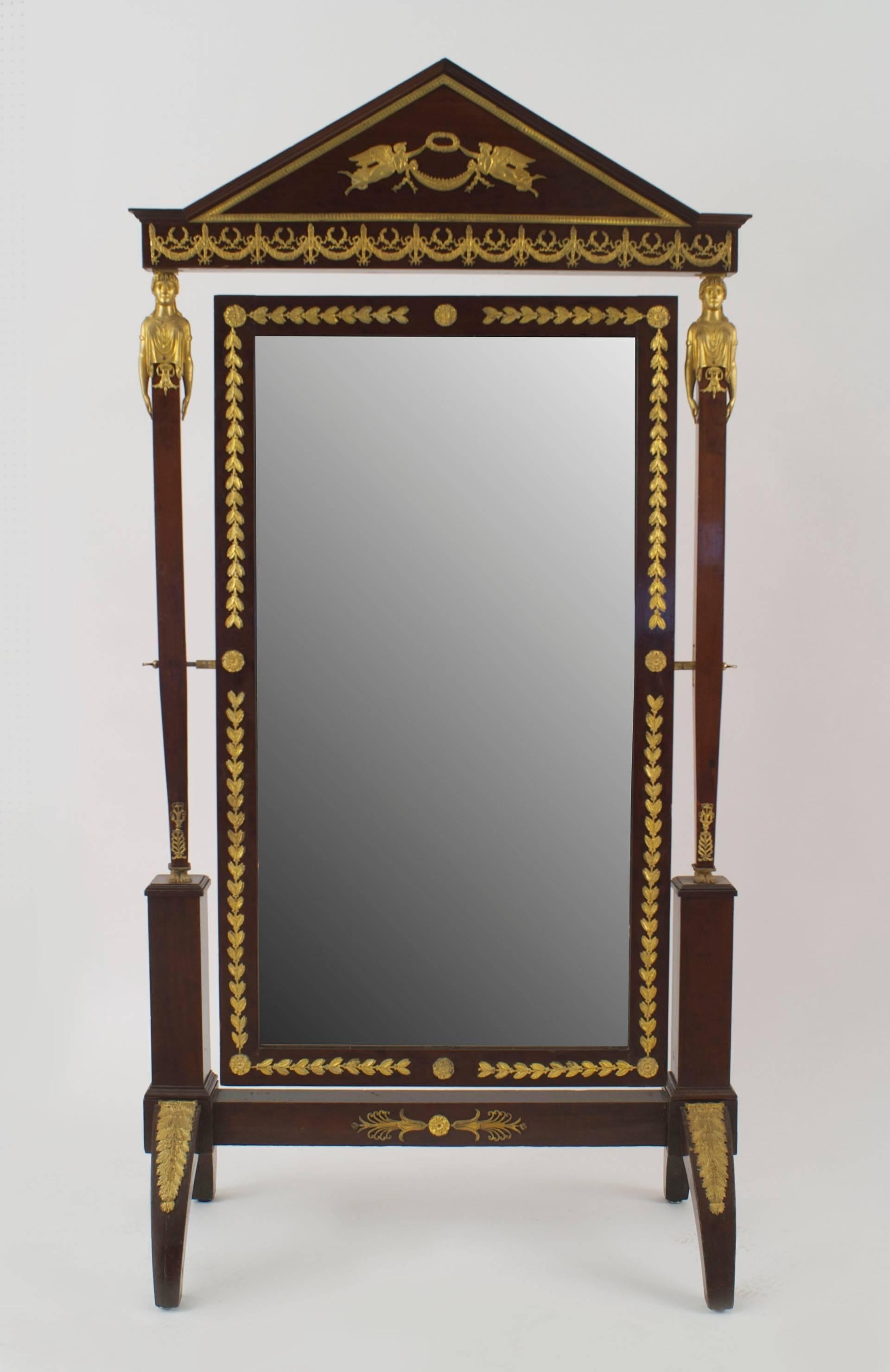 French Empire-style (19th Century) mahogany cheval mirror with bronze trim, caryatid figures, and a pediment top.
