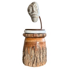 Surrealistische Gesichtsskulptur aus behauenem Stein mit Stahlsockel im Tribal-Stil auf einem Sockel aus unbehandeltem Holz