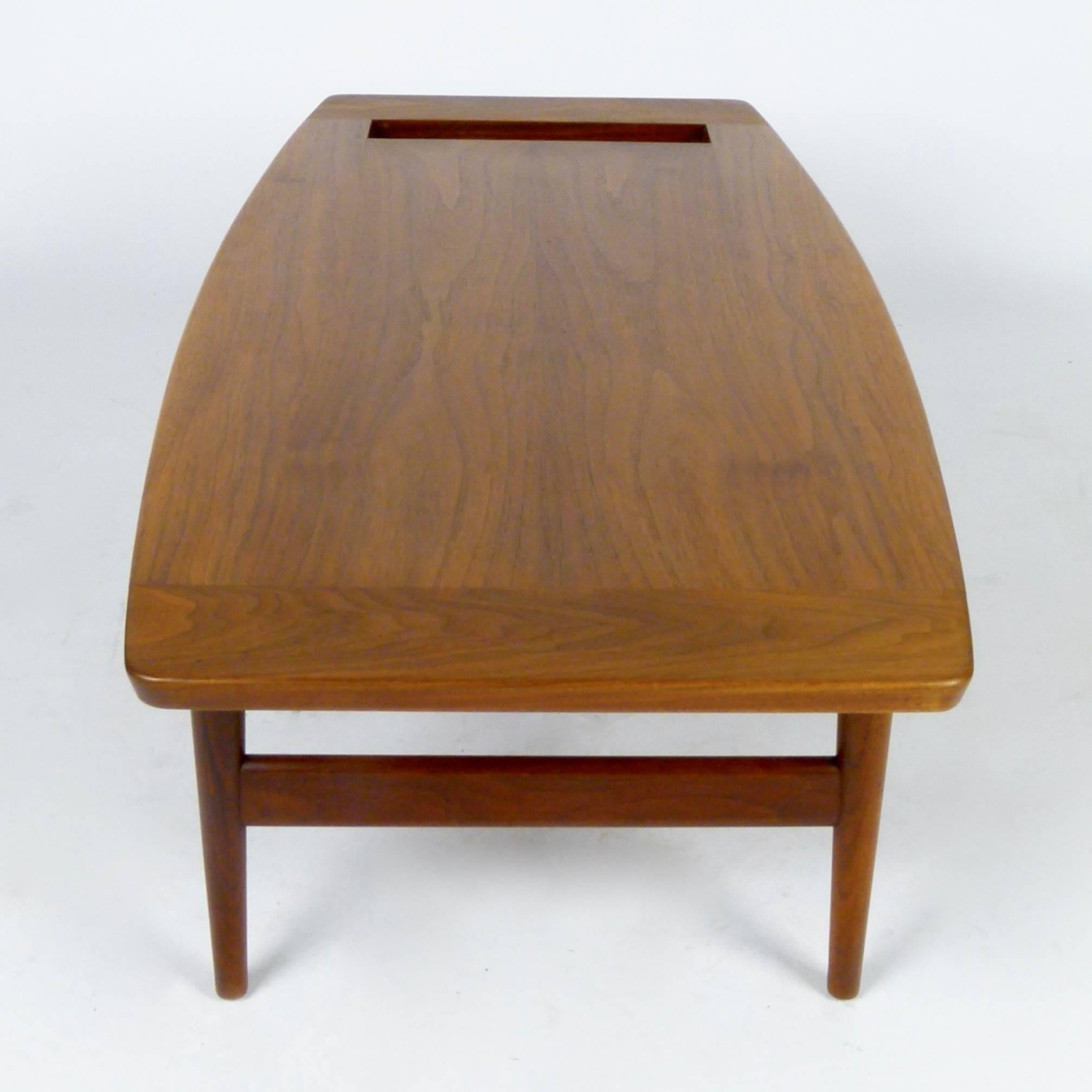 A very special rare and early coffee table by Jens Risom in beautiful oiled walnut with a floating-style top and book or magazine rack, circa 1955.