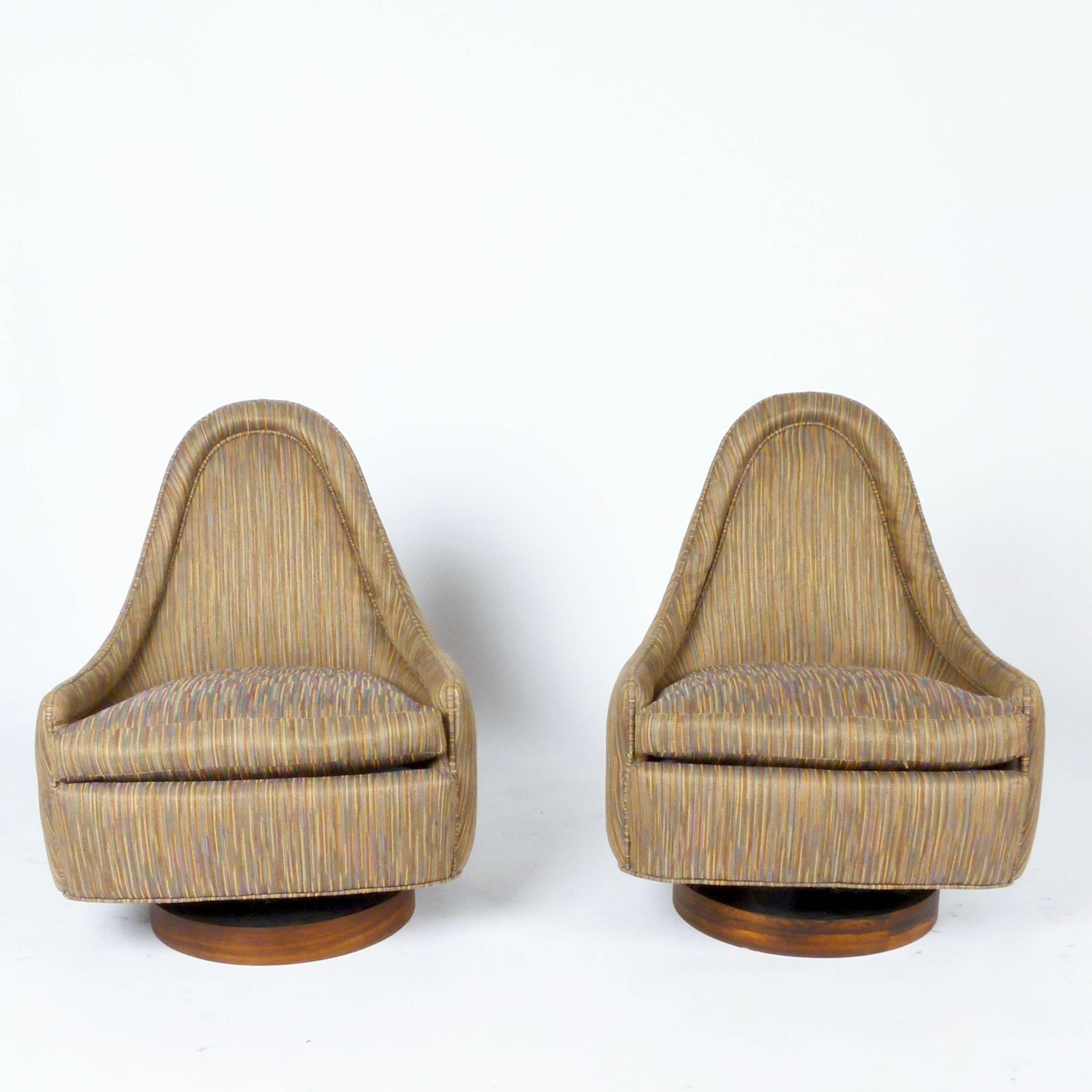 Unique pair of petite form swivel rocking chairs designed by Milo Baughman. Very comfortable upholstered seat over rosewood block base.