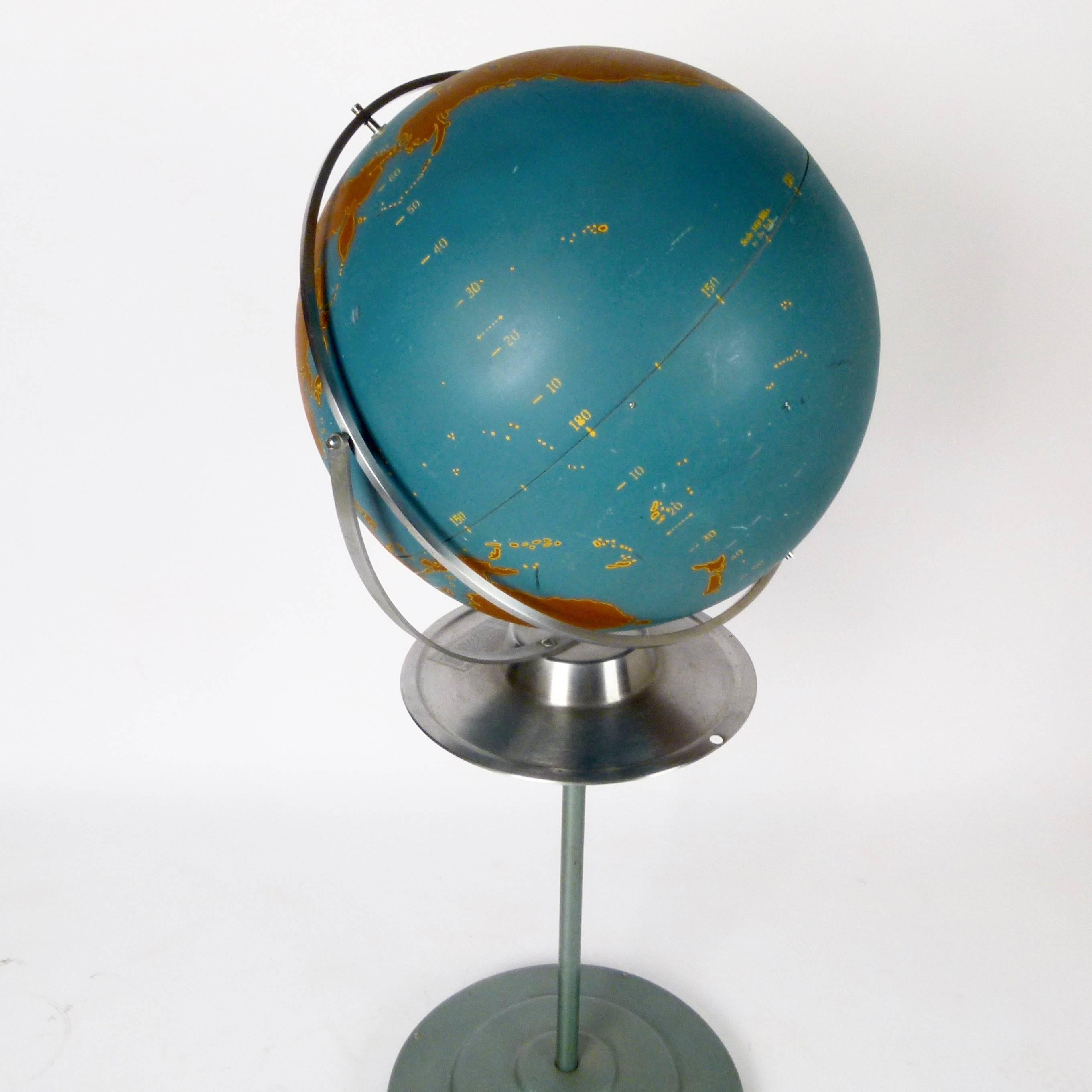 1960s large metal orb globe on telescoping or removable rolling stand with delineated continents, oceans, latitude and longitude numbers, but no geographical names. The globe was originally sold by A.J. Nystom Co. as a teaching tool.