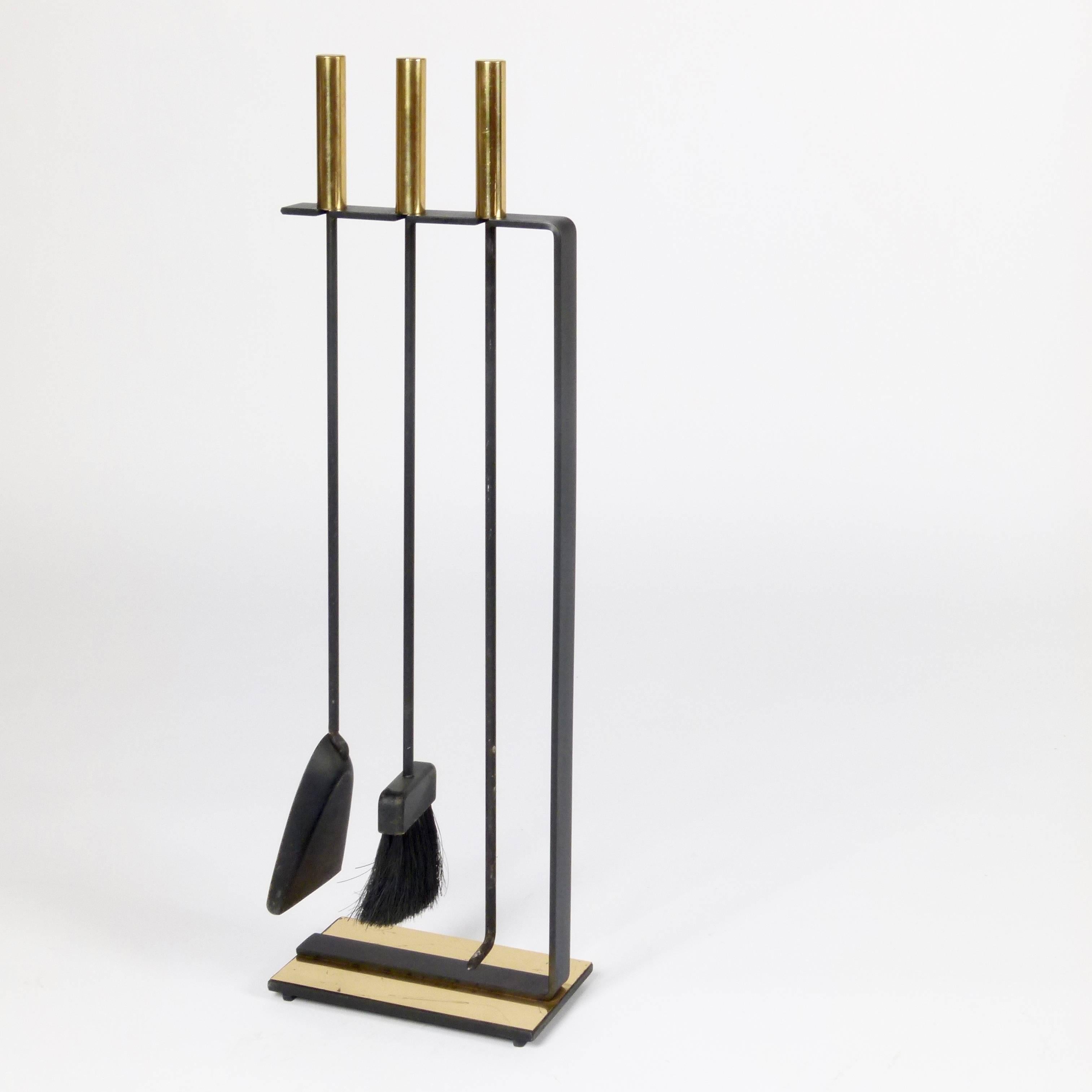 C. 1960 cleaned lined 4-piece fireplace tool set in polished brass and wrought iron by Pilgrim.  This beautiful set has normal wear with perfectly maintained heavy brass handles over wrought iron tool and weighted iron stand.  The only