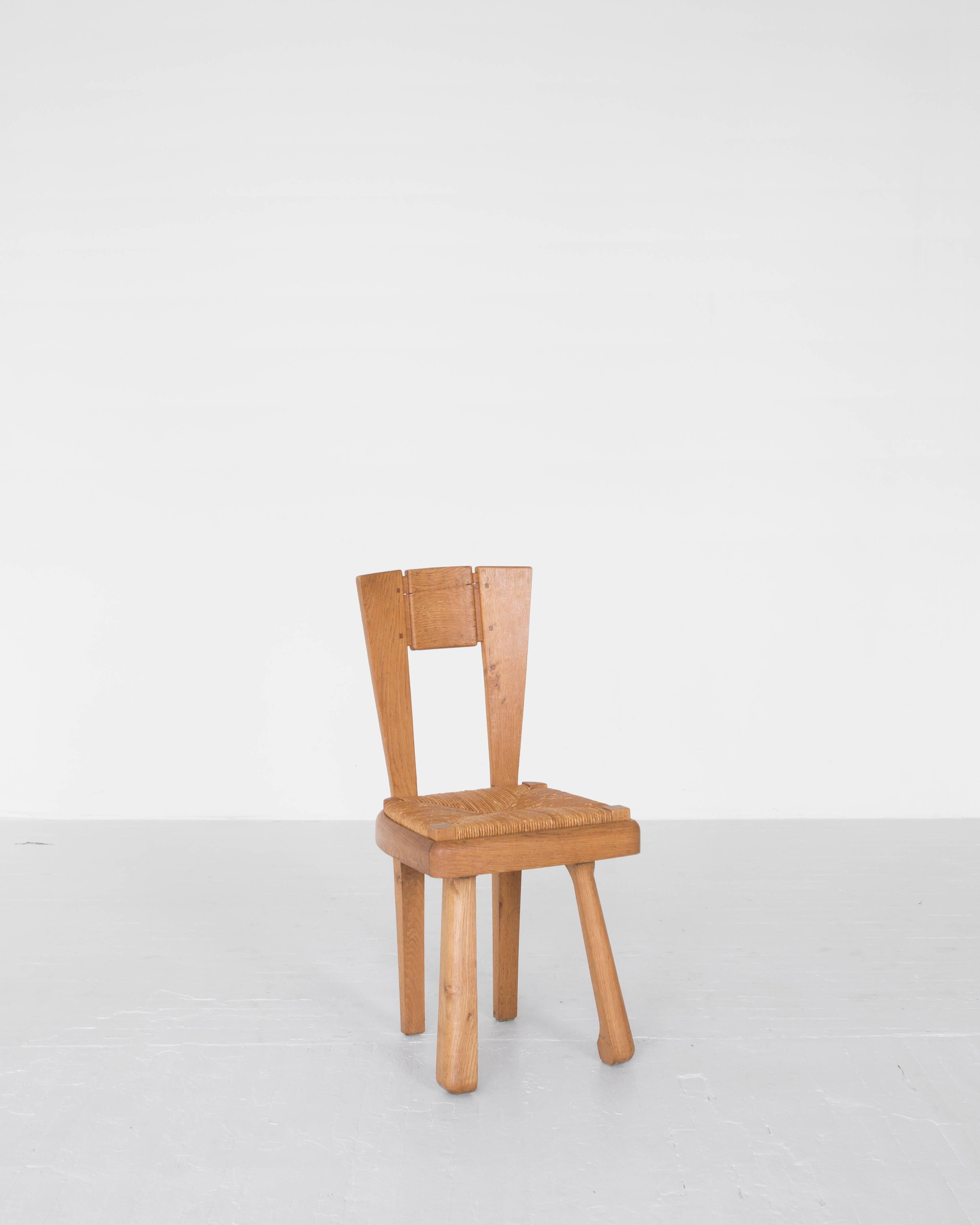 A rare set of six French oak and rush dining chairs with handsome proportions and playful legs, 1950s, France. 

 