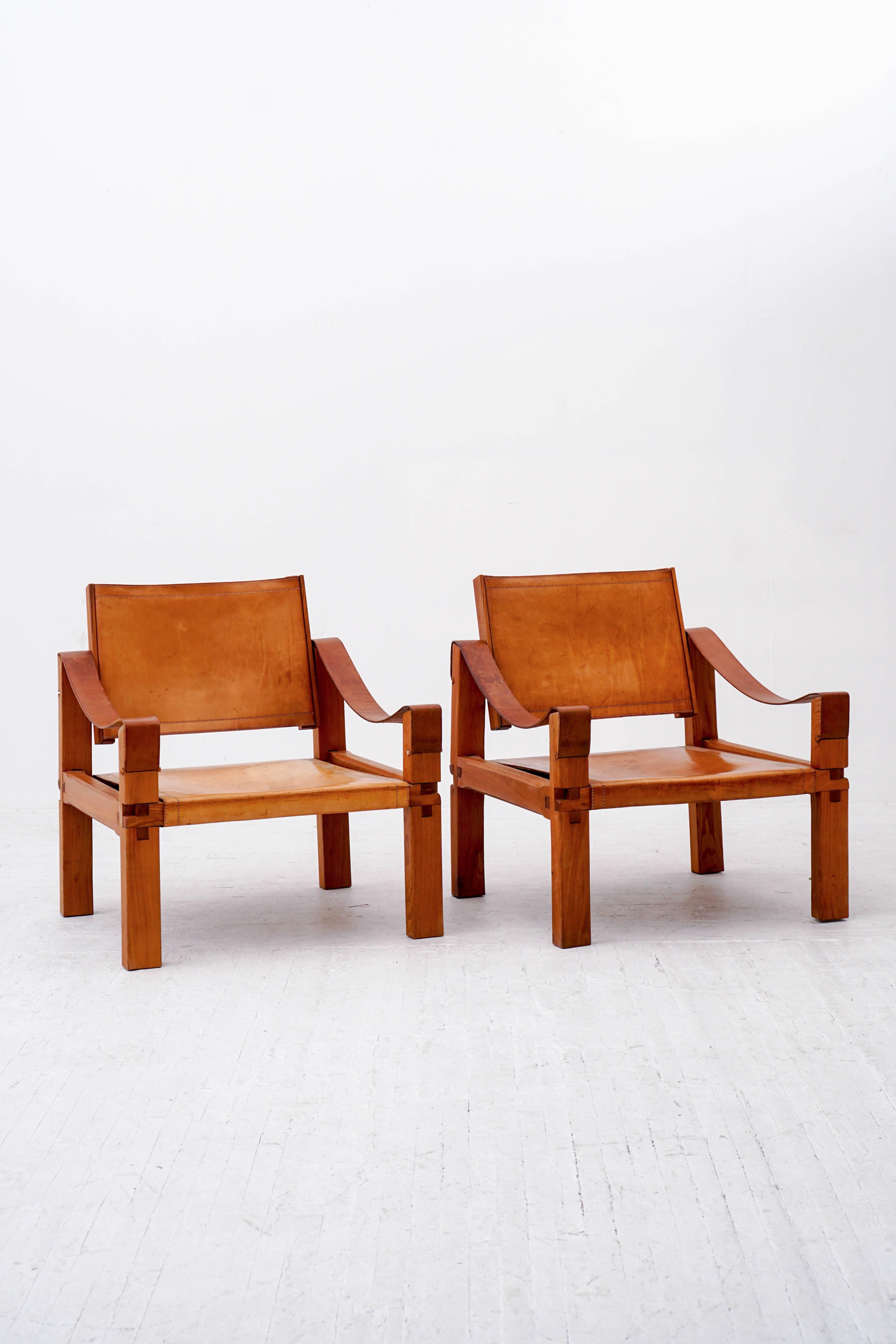 A pair of rare S10 lounge chairs by Pierre Chapo with signature wood joinery and thick saddle leather. fabricated at his atelier circa 1960. They are comfortable and with a tilting back. 

Leather has a beautiful patina while remaining strong and
