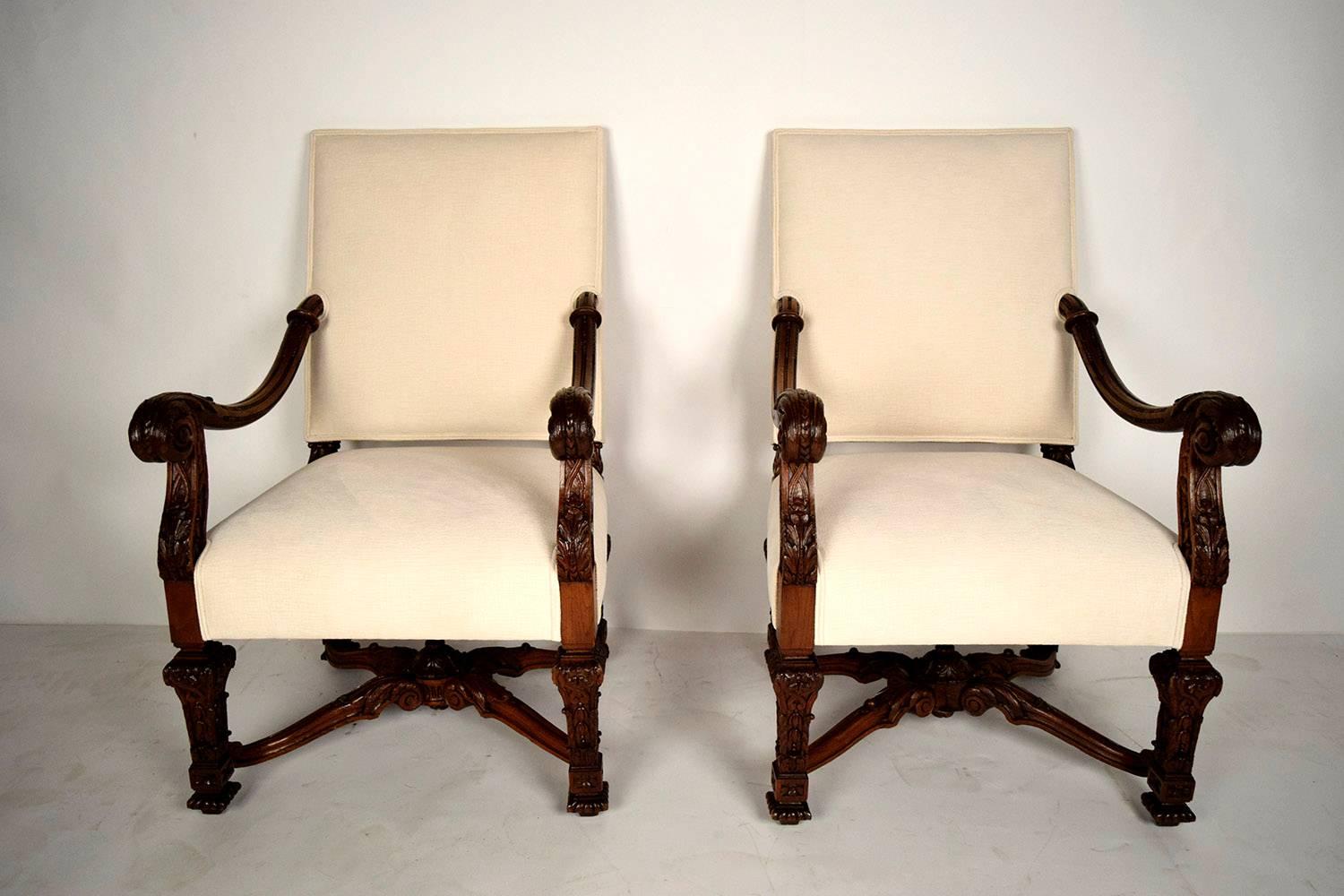 This pair of 1880s French Louis XIV-style bergeres features frames made from hand-carved solid oakwood with its original dark oak finish and stunning patina. On the arms of the chairs there are carved acanthus leaves culminating in a scroll handle.