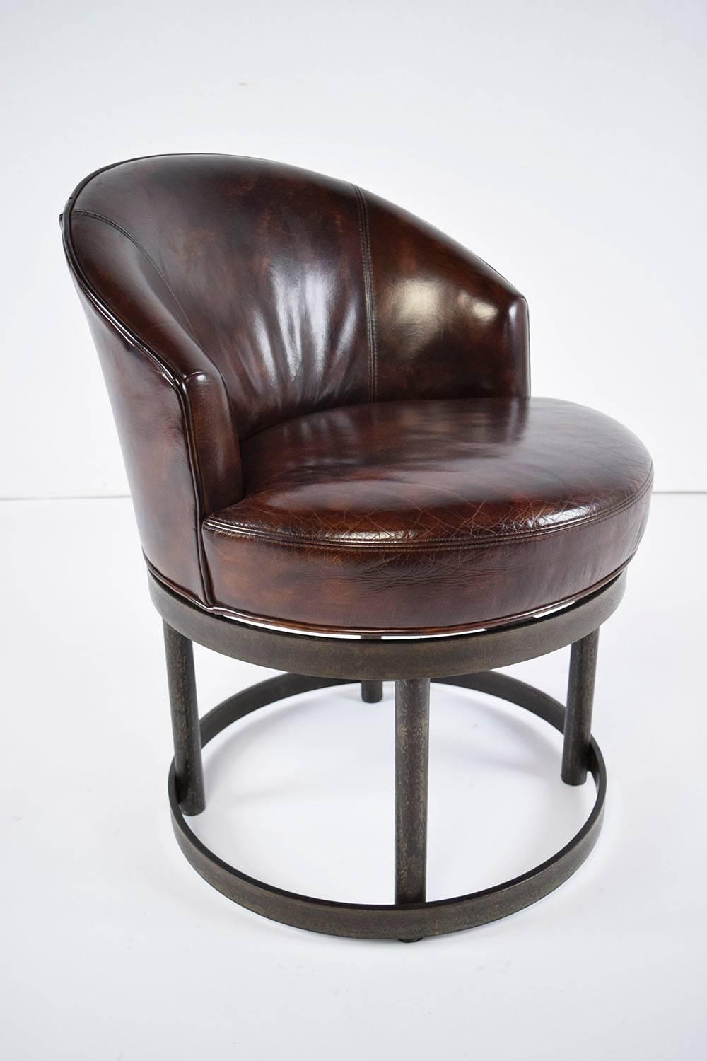 This pair of 1970's Vintage Art Deco-style accent chairs is very unique. The circular, distressed metal bases feature gilt accents and are very sturdy. The seats swivel from side to side and are extremely comfortable. The distressed leather