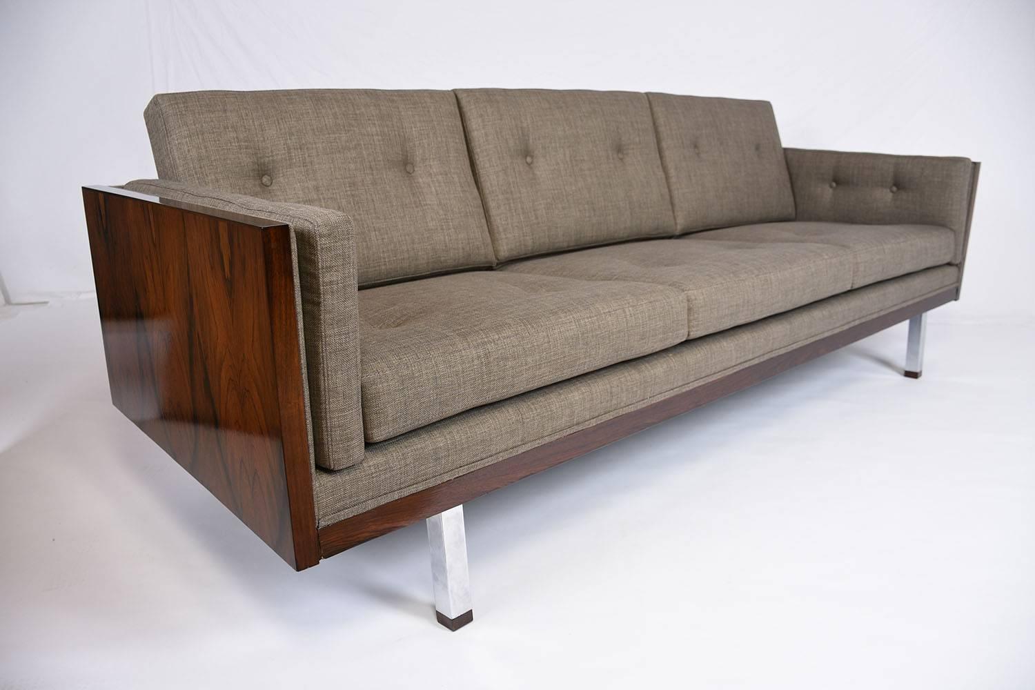 This 1960s Vintage Mid-Century Modern-style cube sofa is designed by Milo Baughman. The frame of the couch has completely been professionally restored with exotic rosewood veneers in a beautiful, rich walnut color stain and lacquered finish. The