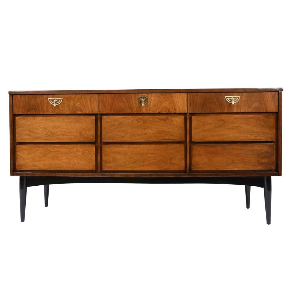 This 1960s Vintage Mid-Century Modern nine drawers is made from walnut wood in a rich walnut and black color combination and a lacquered finish. There are nine drawers for ample storage space. The top three drawers have beautiful, geometric