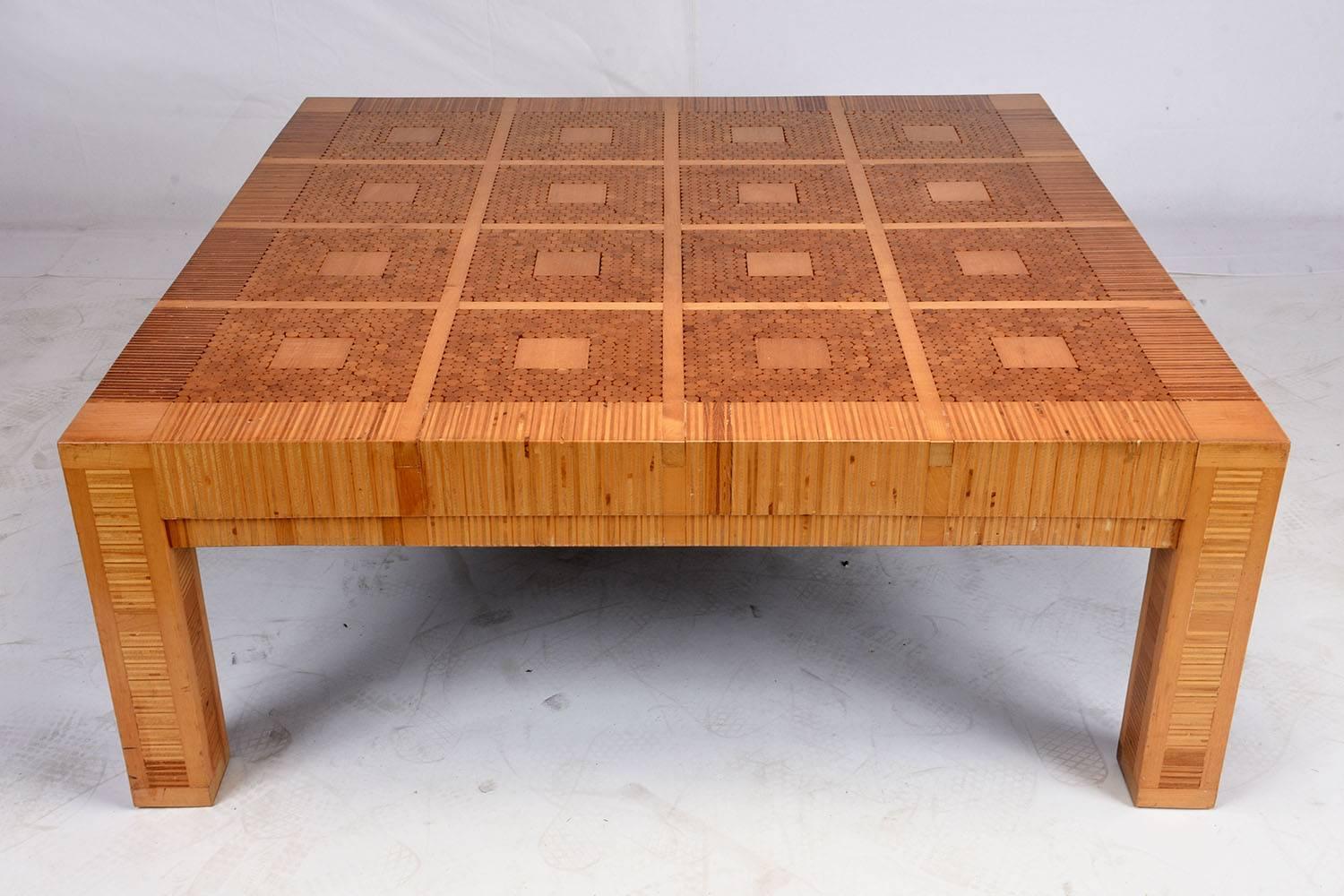 This 1970s Modern-style coffee table is made from wood that is inlaid in a geometric pattern and features a natural finish. The square pattern is offset by the vertical inlay pattern on the legs. This unique coffee table is sturdy, stylish and ready