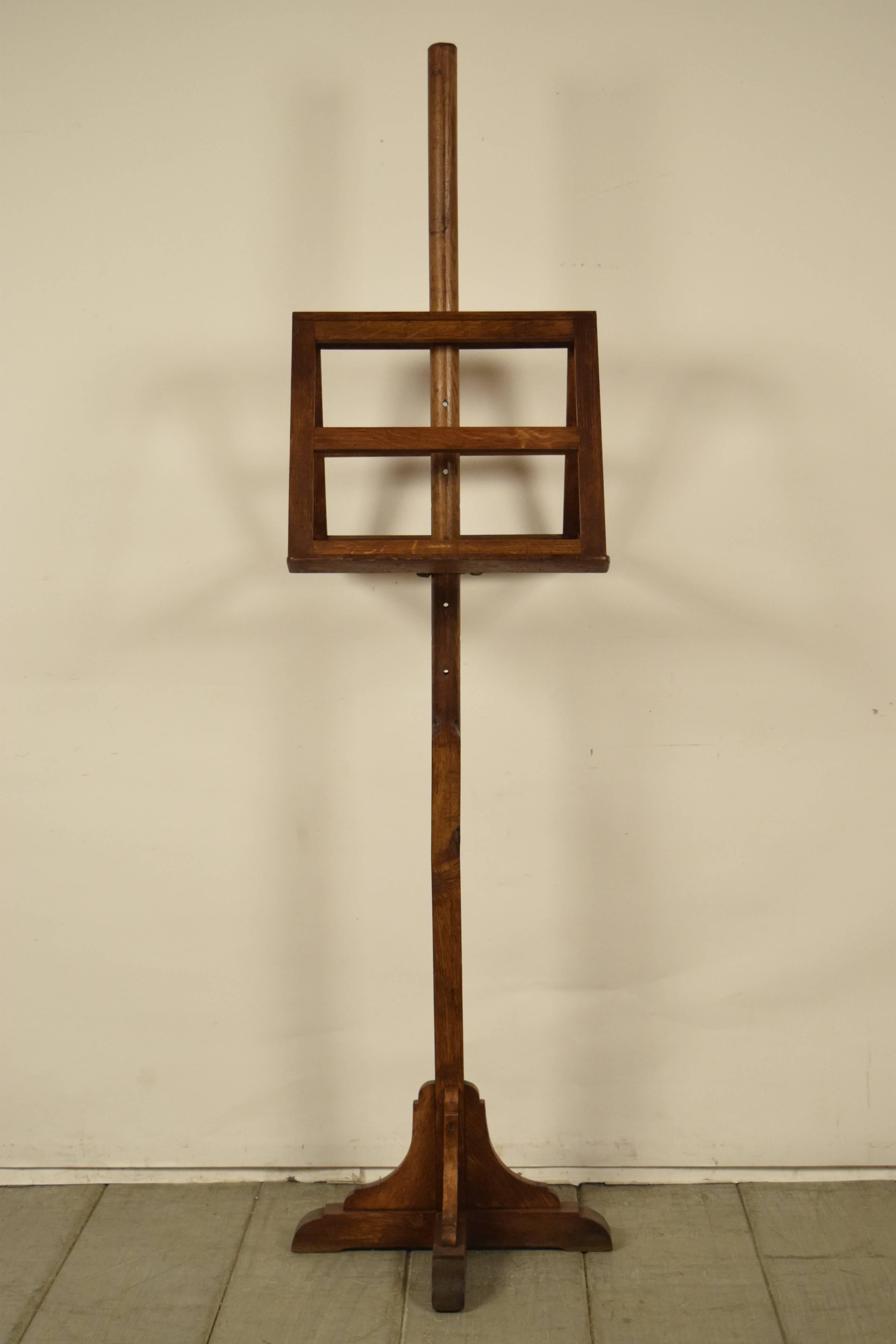 One of a kind French antique solid oakwood duet music stand. The top is double sided, and the height can be adjusted as you please. It has multiple uses for displaying items. It is made of solid oakwood with a walnut finish, and is supported by a