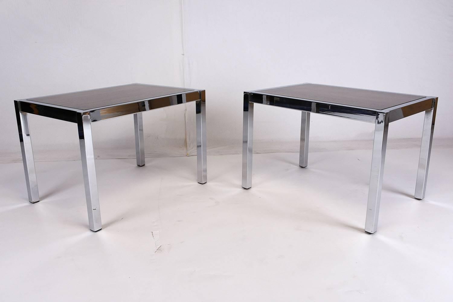 This pair of 1970s Mid-Century Modern style side tables feature a simple, but elegant chrome frame. The base is highlighted by a rosewood top with a rich stain and a lacquered finish. This pair of side tables is sturdy, stylish, and ready to be used
